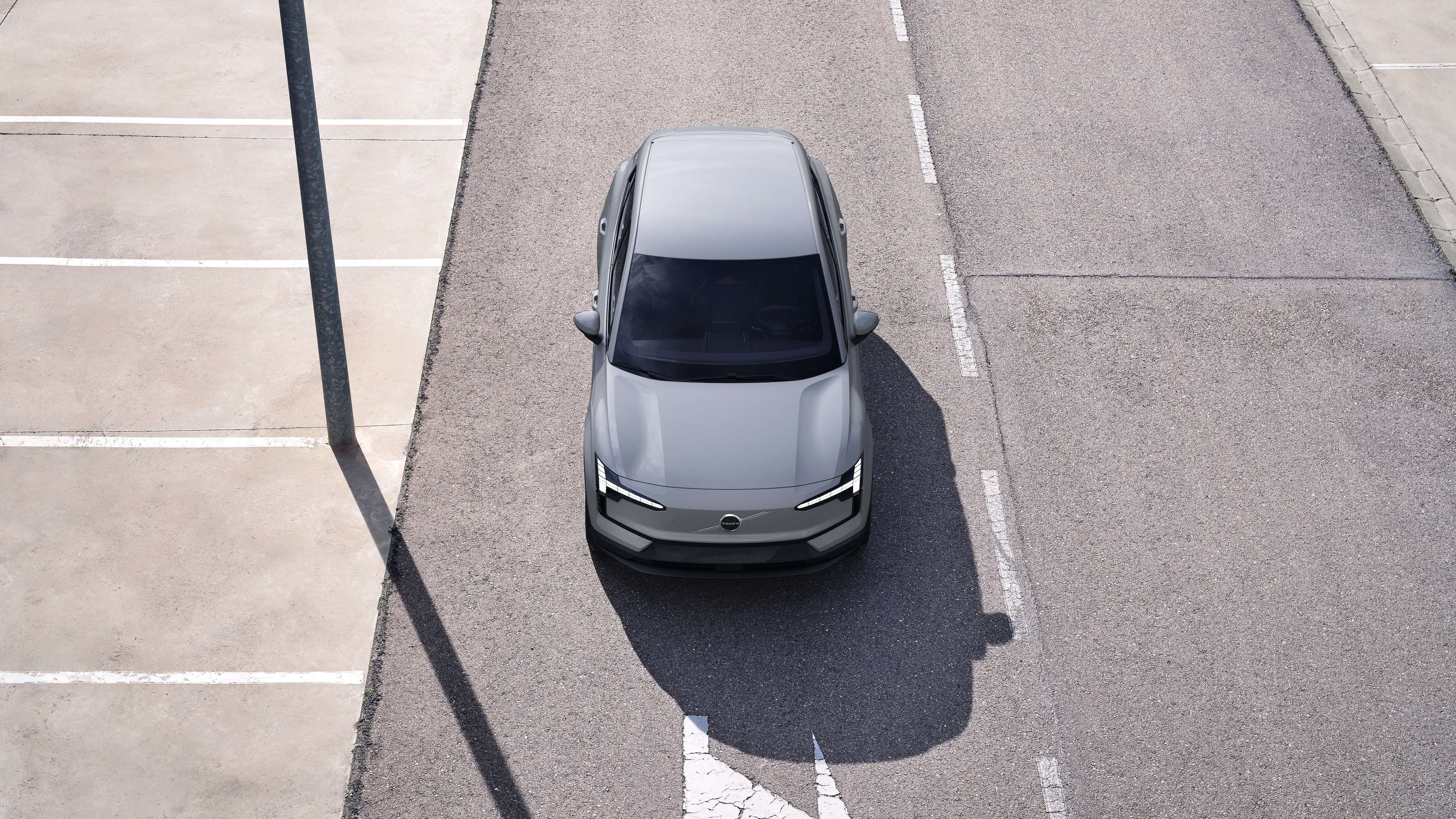 Volvo-bíll að utan í þriggja fjórðu hluta götubakgrunns í þéttbýli sem sýnir aðra hliðina, þakið og hluta framhliðarinnar.