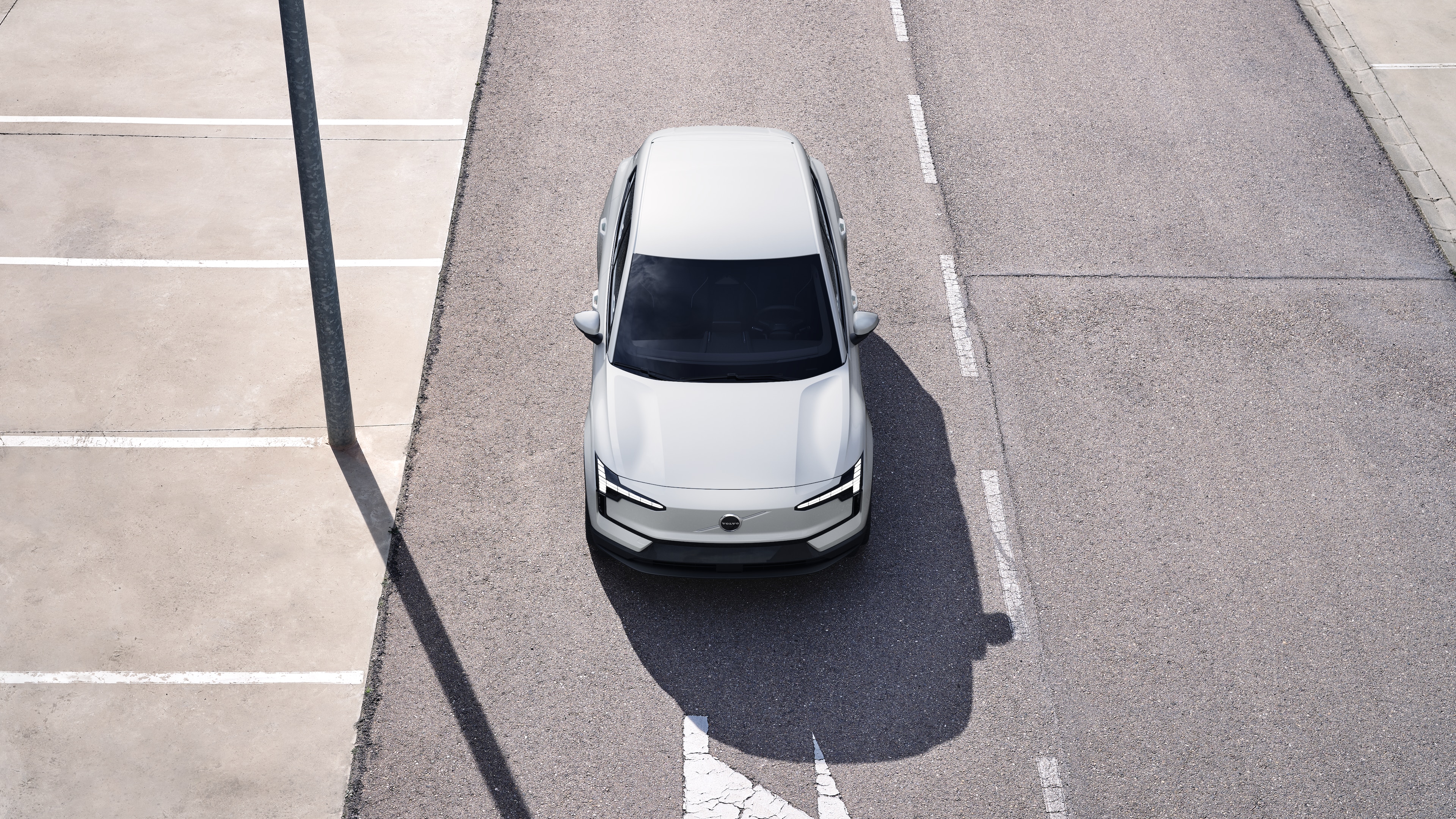 Volvo car exterior in three-quarter view on an urban street background, showing one side, roof, and part of the front.