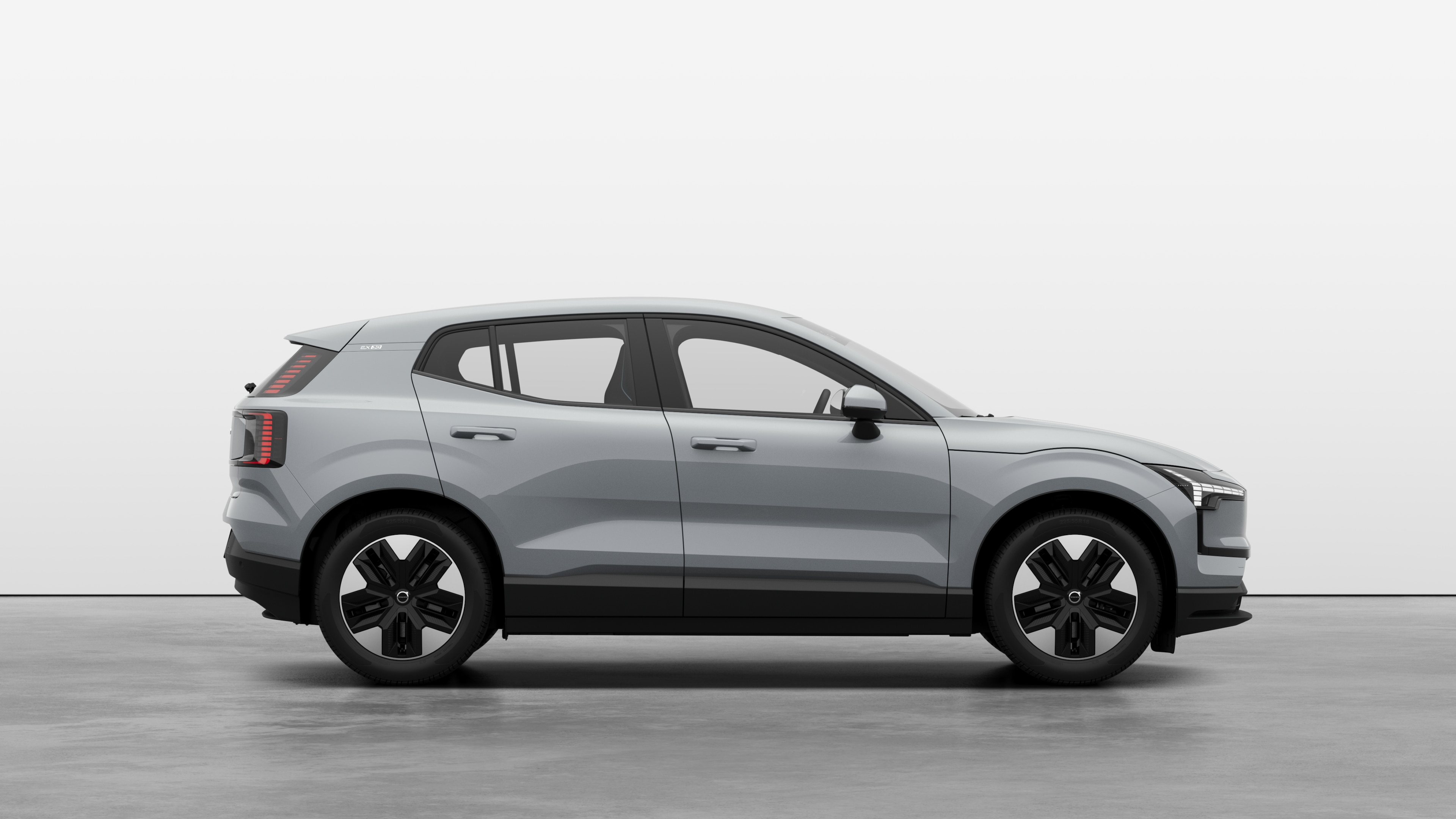 Volvo car side view on plain studio background displaying closed doors and visible wheel design.