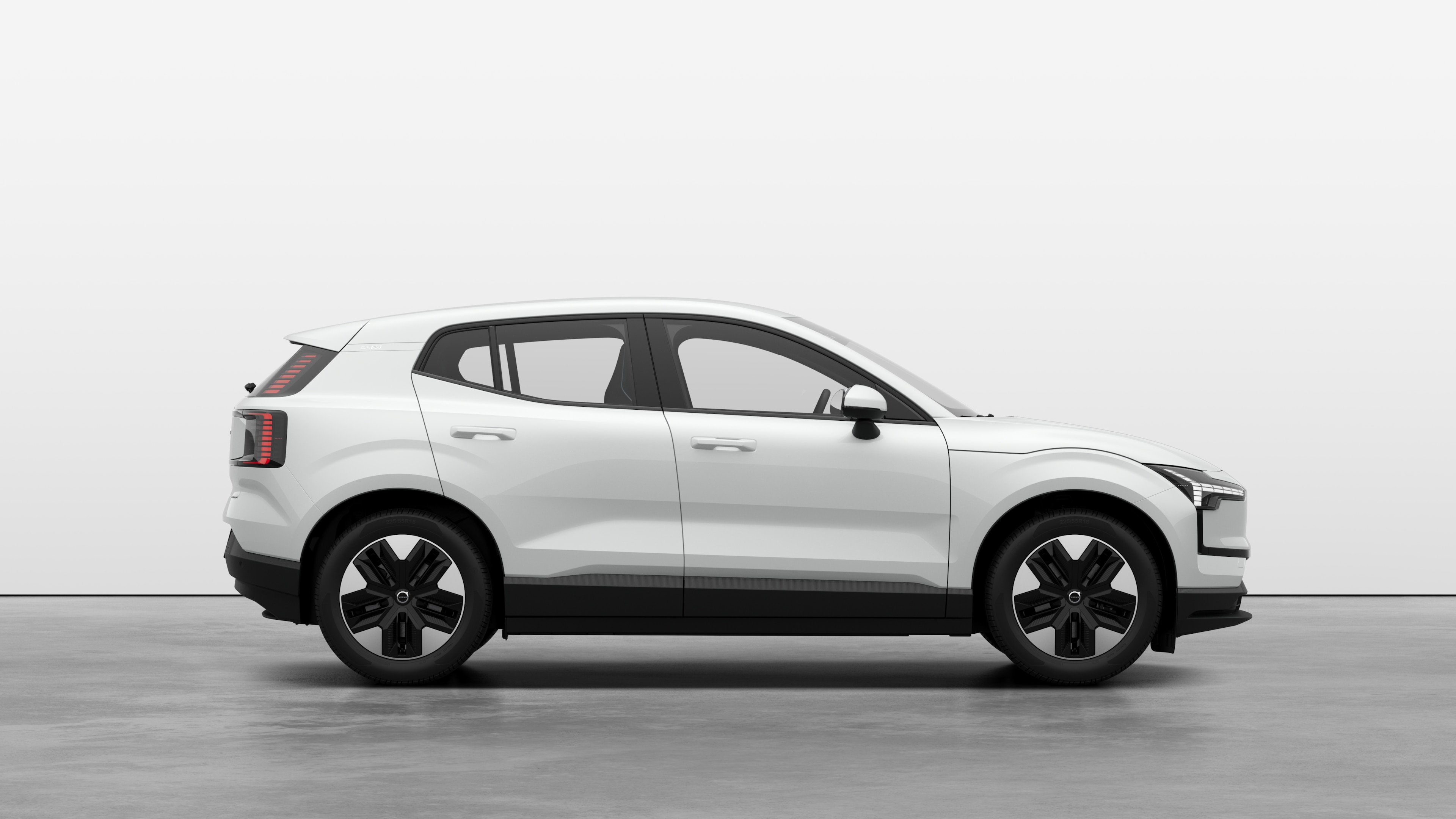 Volvo car side view on plain studio background displaying closed doors and visible wheel design.