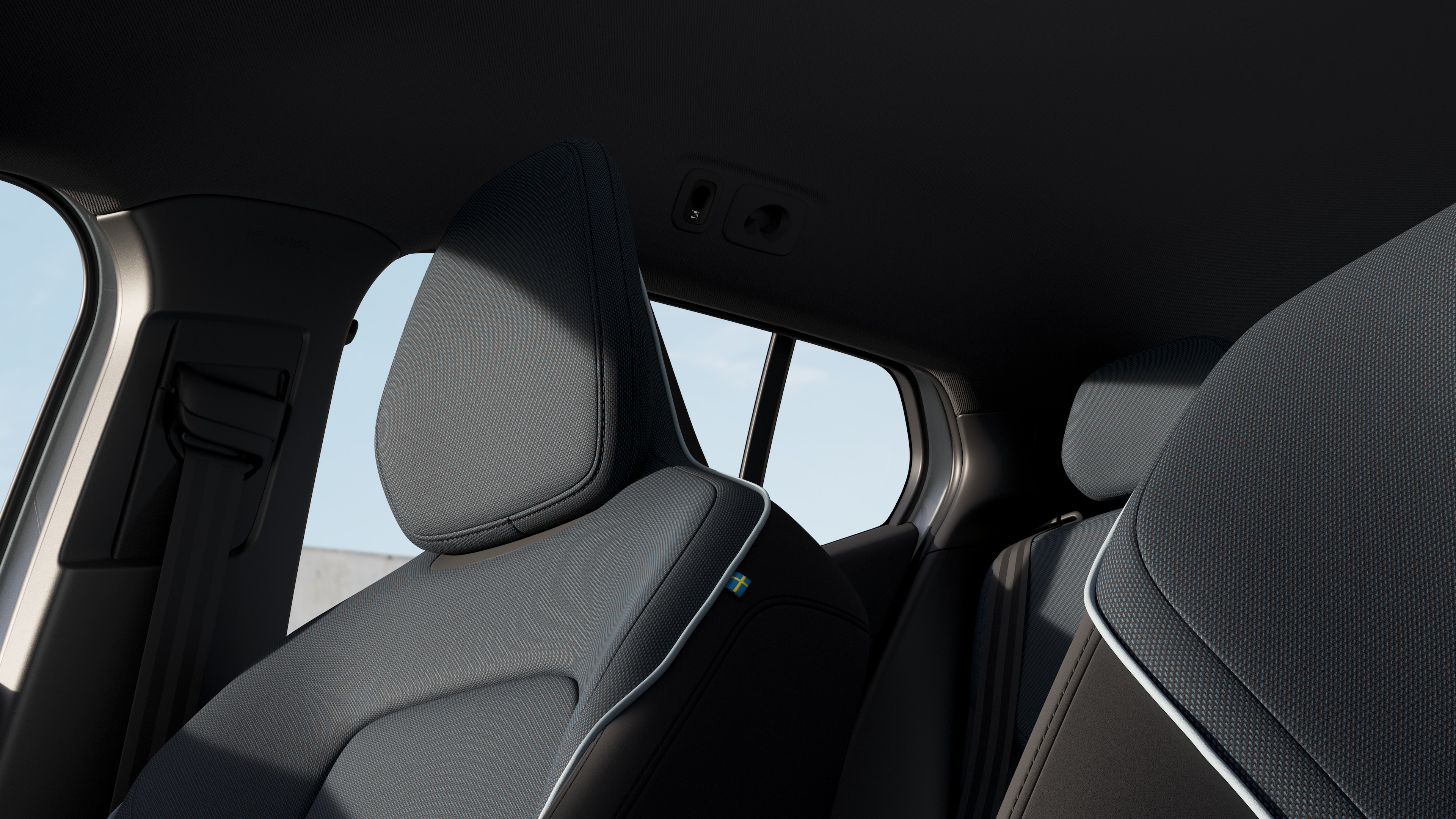 Volvo car interior showing front and rear passenger seats, steering wheel, dashboard, and center console against a plain studio background.