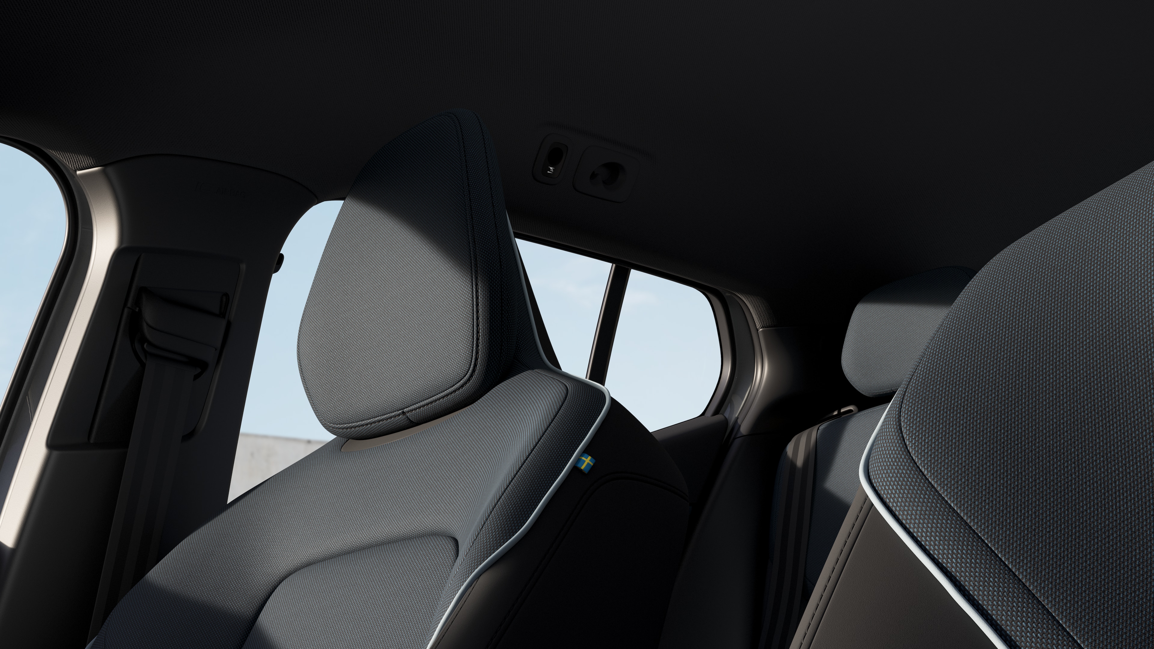 Volvo car interior showing front and rear passenger seats, steering wheel, dashboard, and center console against a plain studio background.