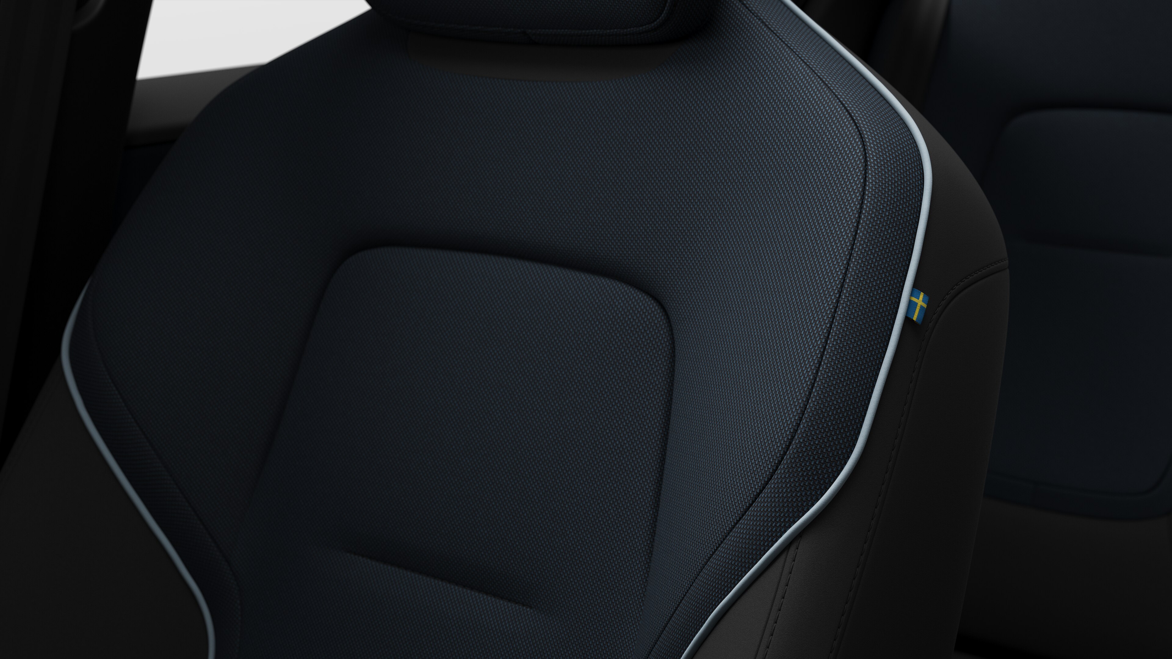 Grande plano dos detalhes do banco interior do automóvel Volvo a mostrar as costuras e uma pequena etiqueta da bandeira sueca.