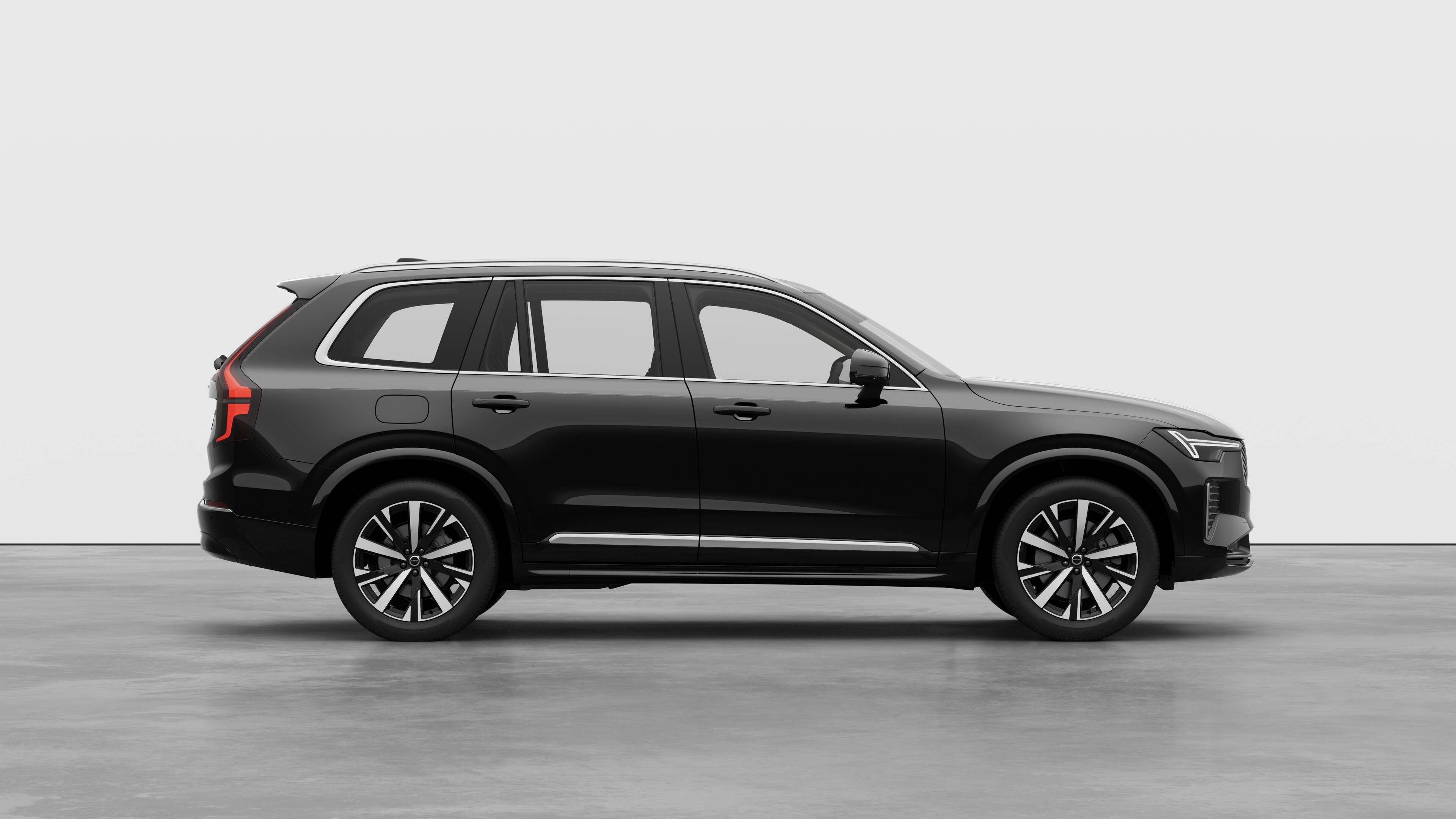 Volvo car side view on plain studio background displaying closed doors and visible wheel design.