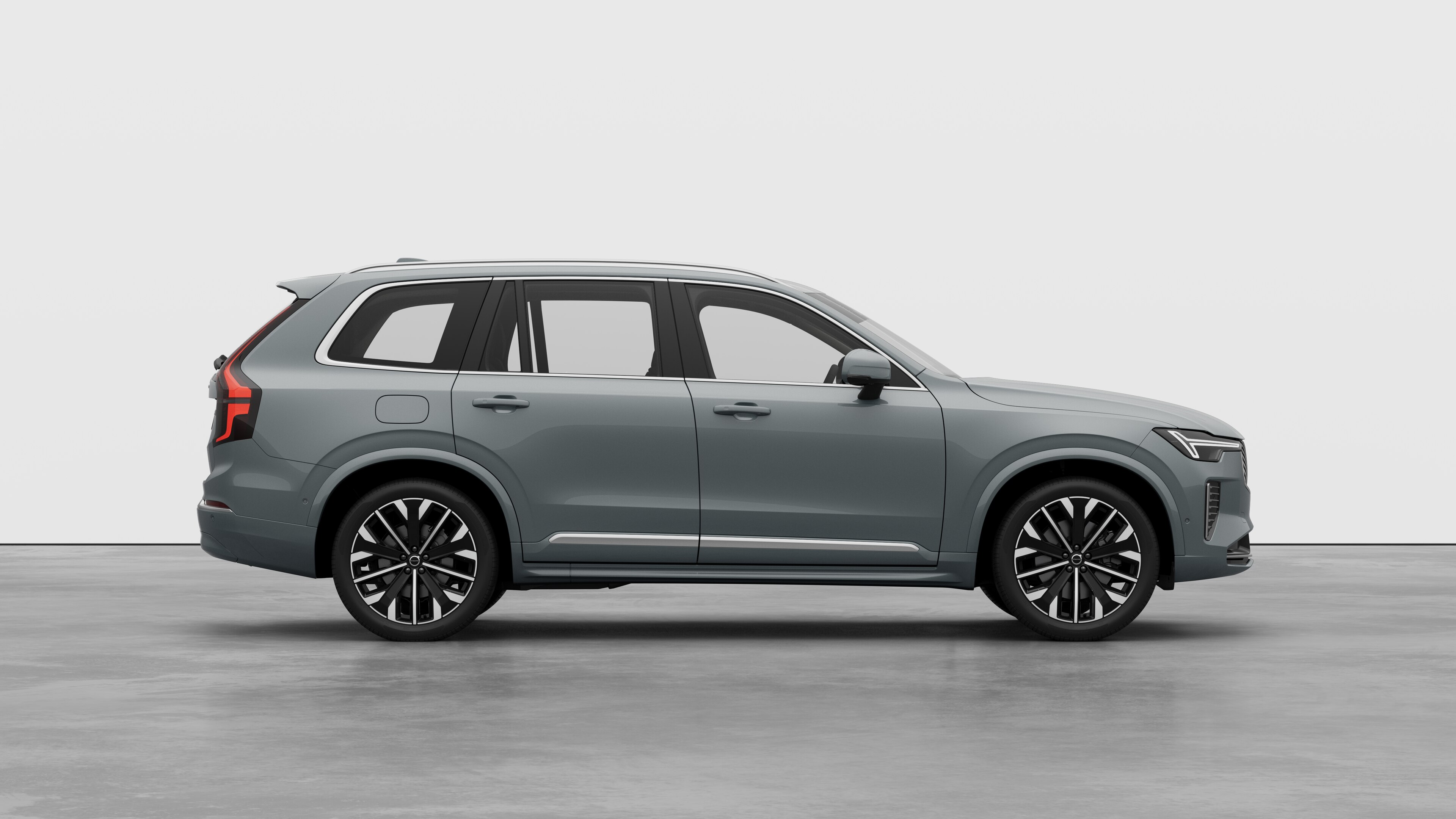 Volvo car side view on plain studio background displaying closed doors and visible wheel design.