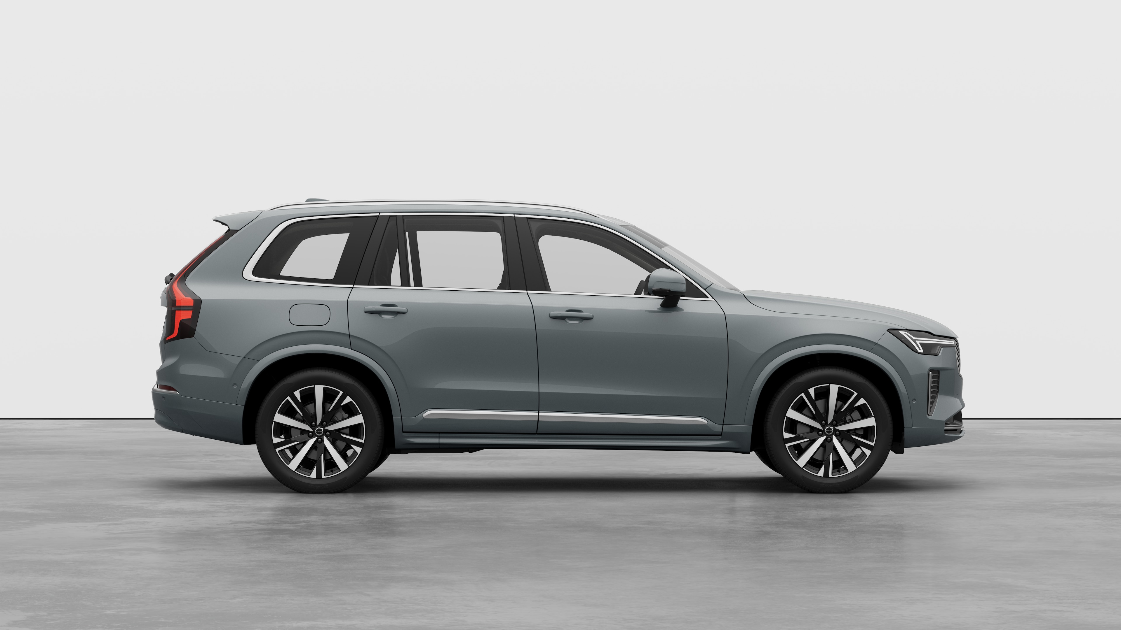 Volvo car side view on plain studio background displaying closed doors and visible wheel design.
