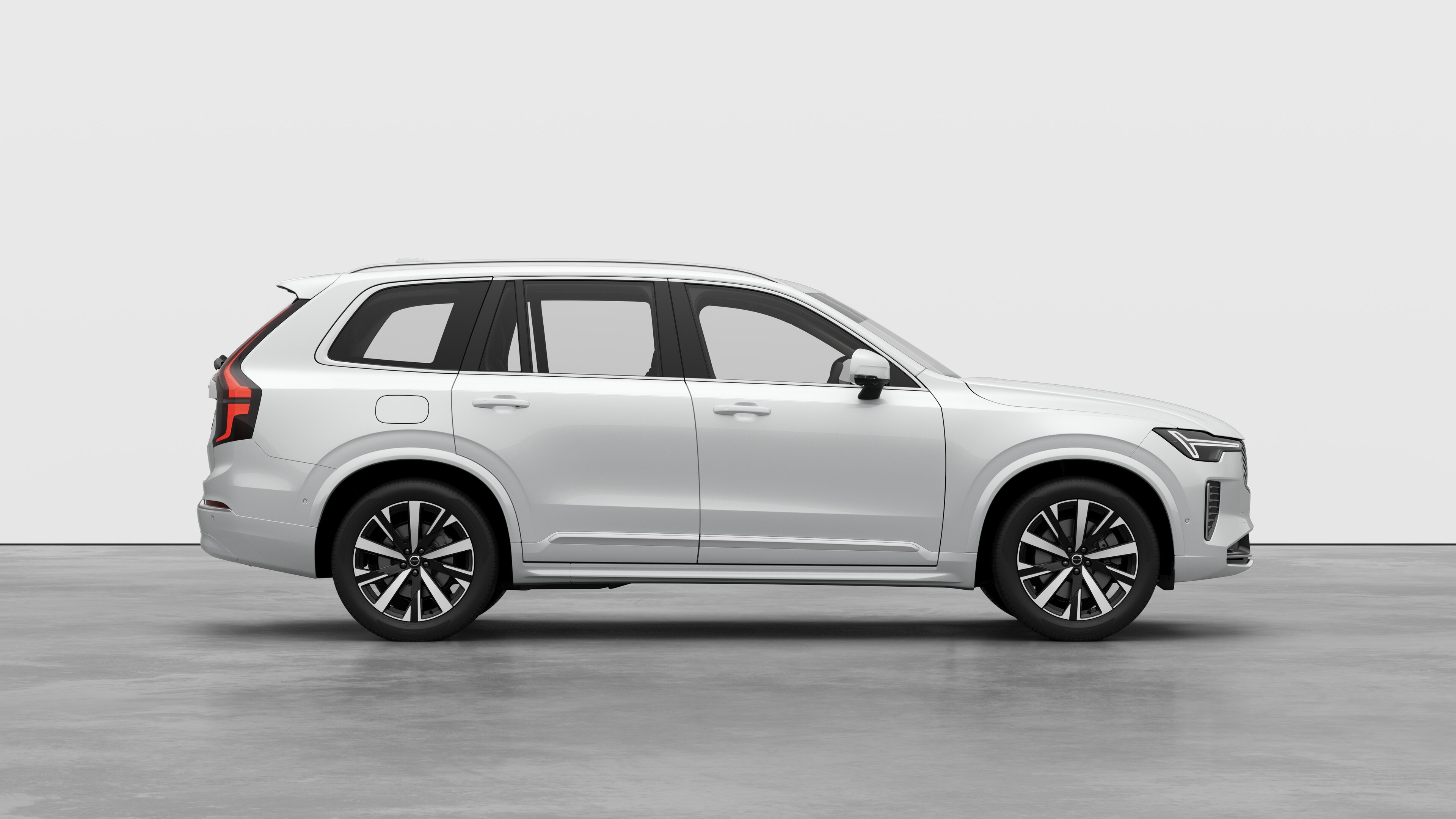 Volvo car side view on plain studio background displaying closed doors and visible wheel design.
