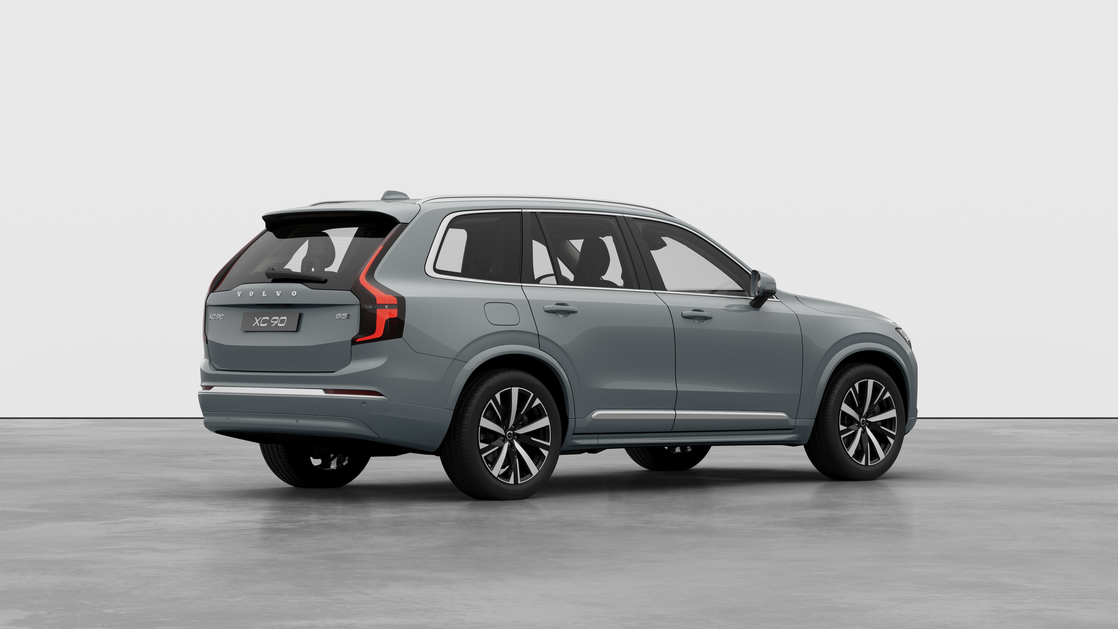 Вид сзади автомобиля Volvo в три четверти на однотонном студийном фоне.