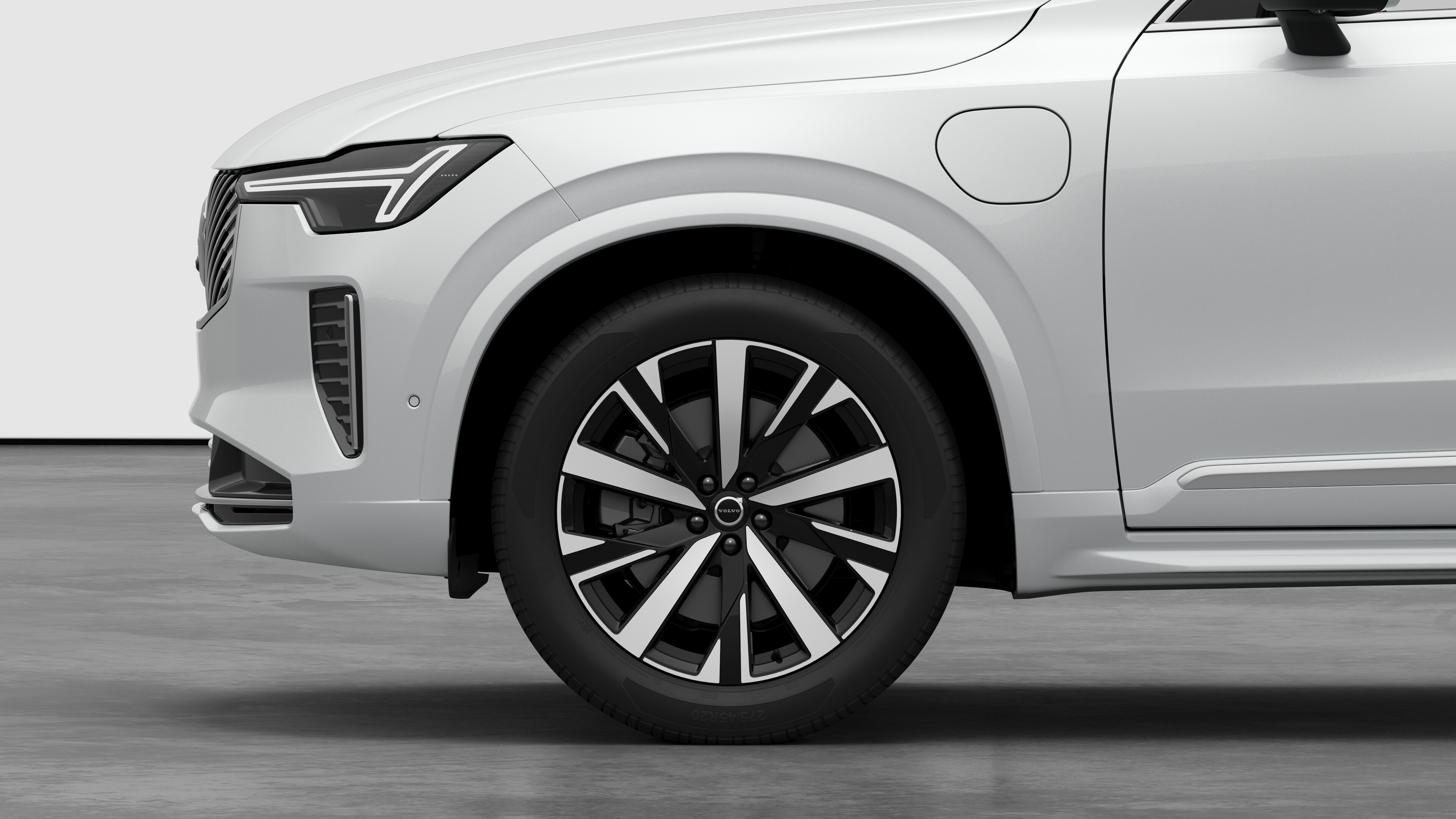 Volvo car exterior side view focusing on the front wheel and fender, set against a plain studio background.