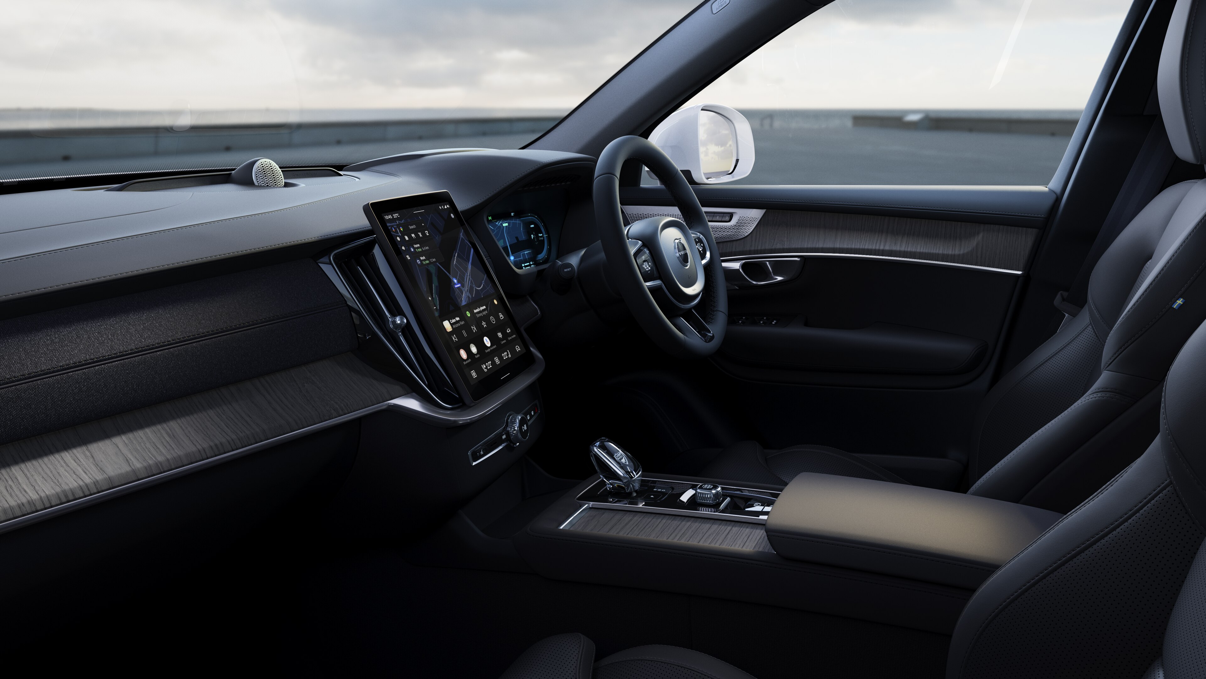 Volvo car interior showing dashboard, steering wheel, and center console with digital display in an open road background.