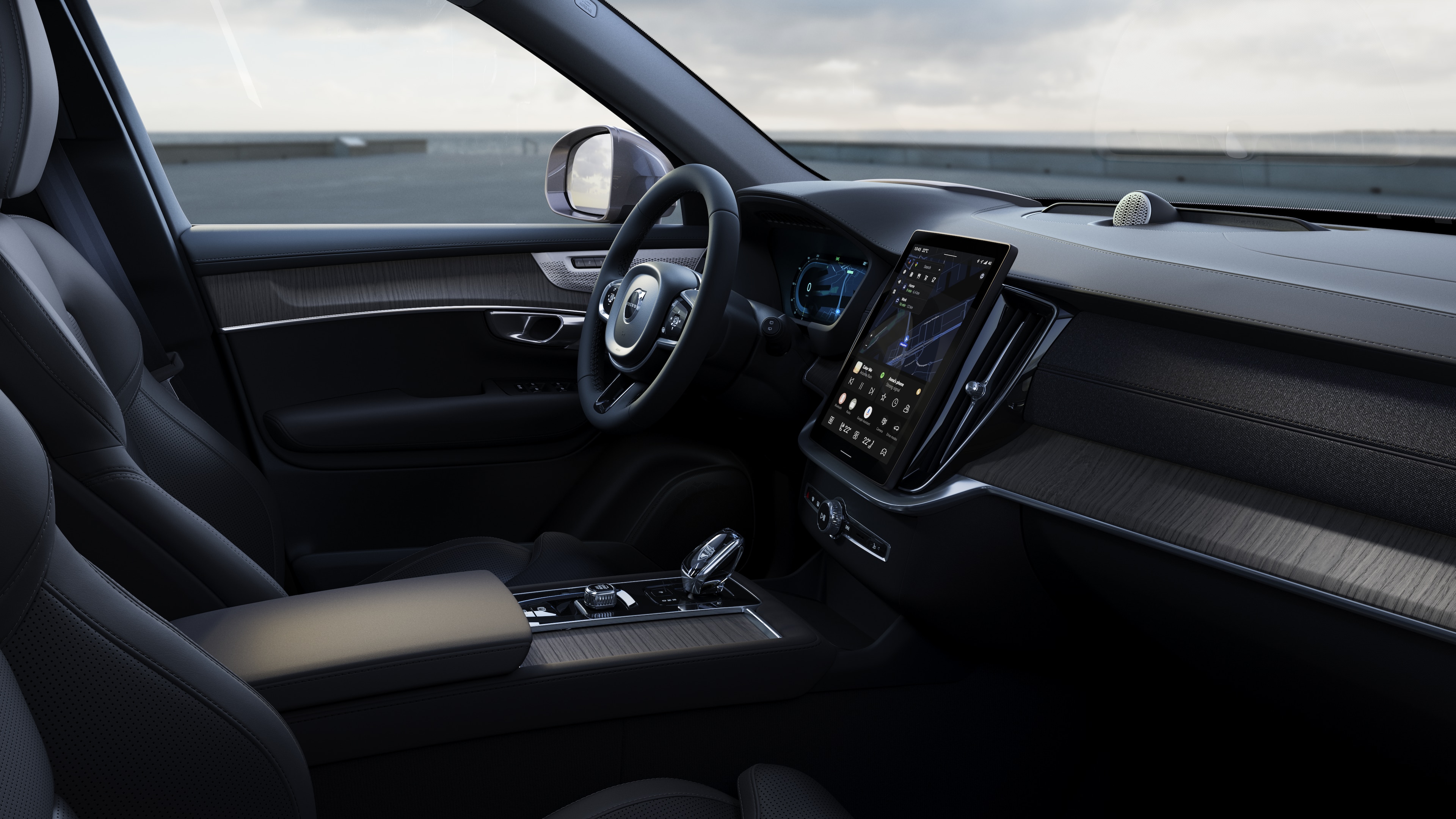 Volvo 汽車內裝顯示儀錶板、方向盤和中控台，並在開放道路背景下顯示數字顯示幕。