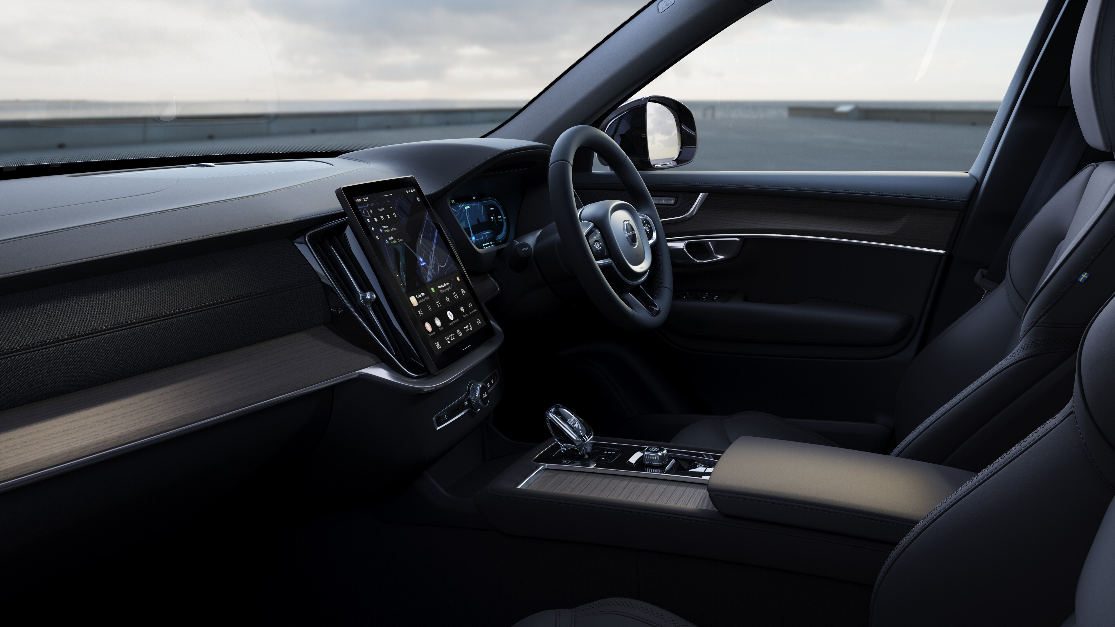 Volvo car interior showing dashboard, steering wheel, and center console with digital display in an open road background.