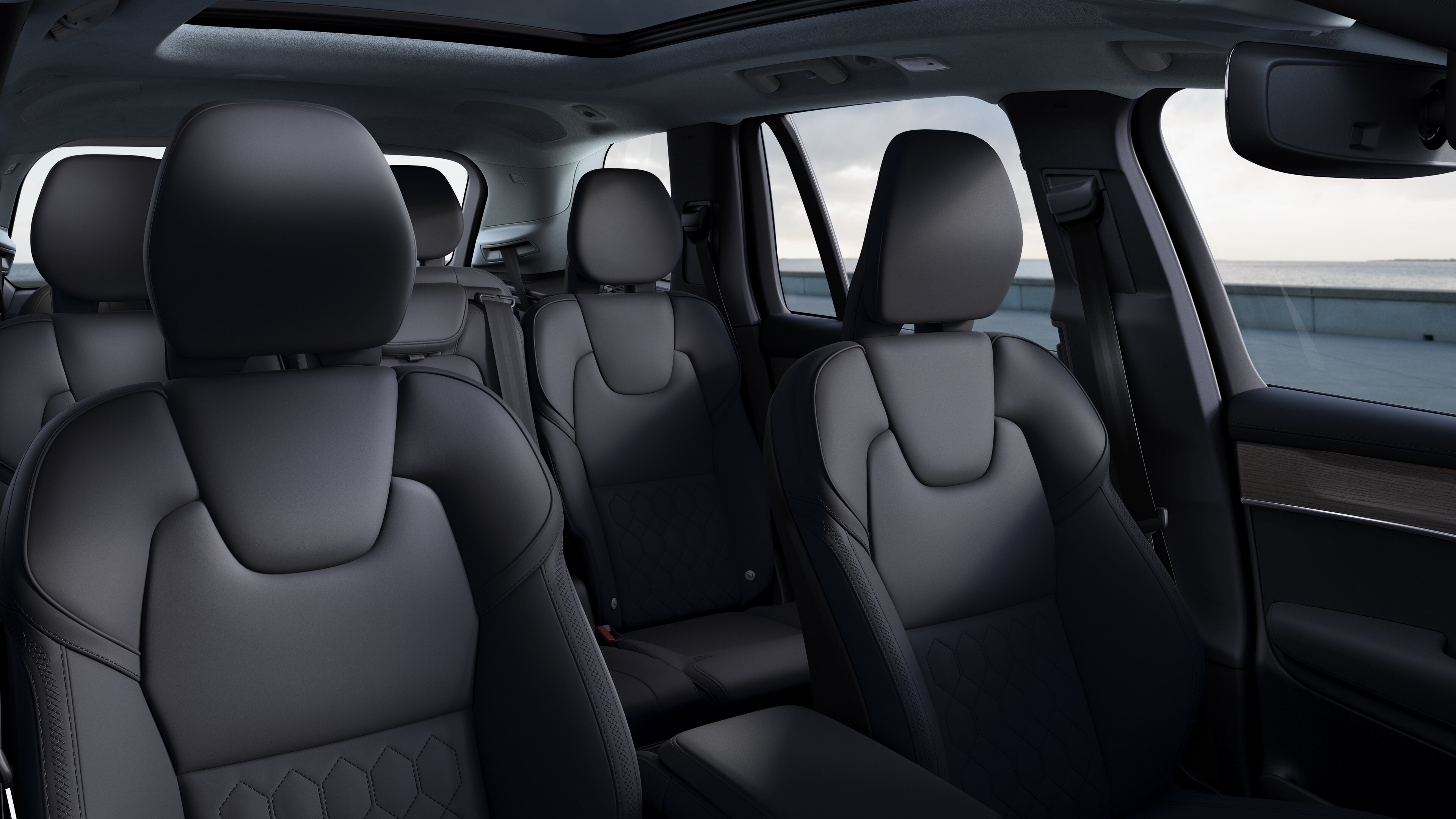 Интерьер автомобиля Volvo с передними и задними пассажирскими сиденьями, рулем, приборной панелью и центральной консолью на фоне студии.