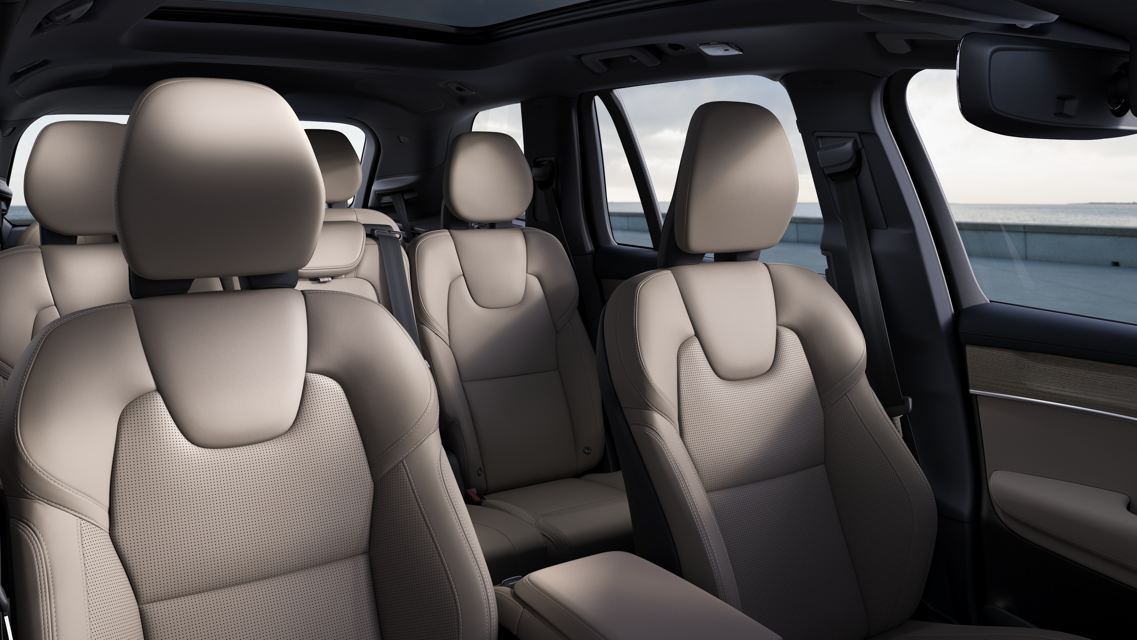 평범한 스튜디오 배경에 앞좌석 및 뒷좌석 조수석, 스티어링 휠, 대시보드 및 센터 콘솔을 보여주는 볼보 자동차 내부.