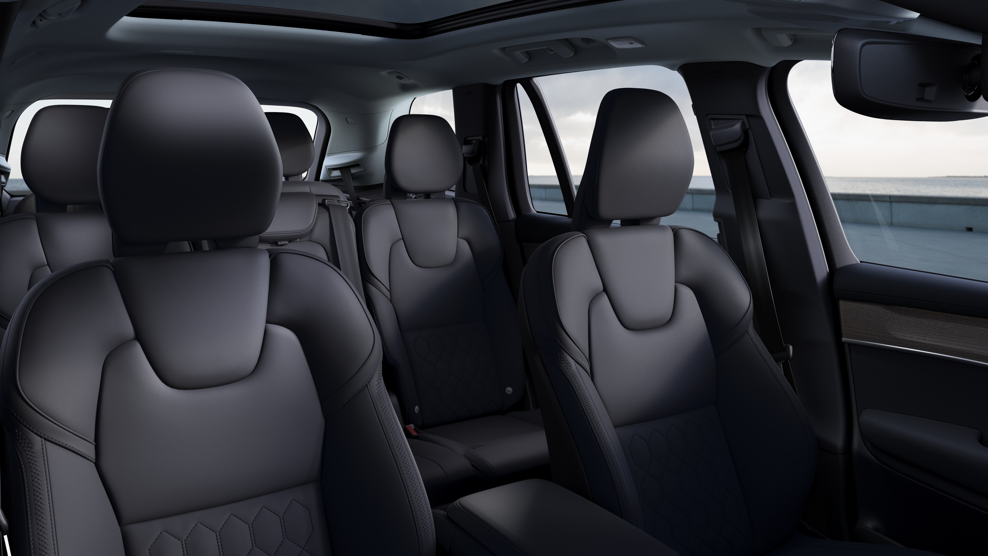 Interior del vehículo Volvo que muestra los asientos delanteros y traseros de los pasajeros, el volante, el salpicadero y la consola central sobre un fondo de estudio liso.