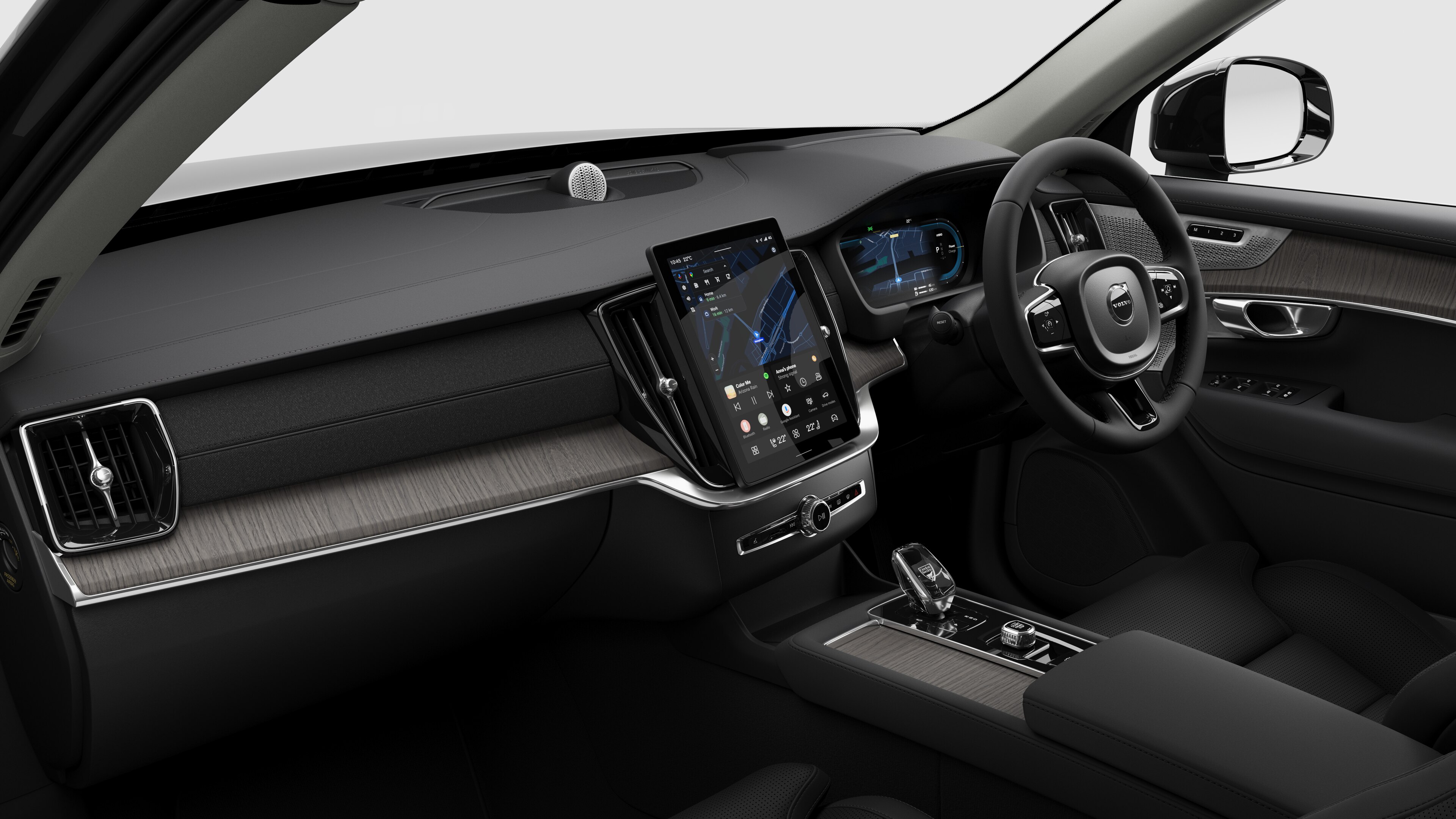 Interior view of a Volvo car showing the dashboard, steering wheel, center console, and digital display screen in a plain studio background.