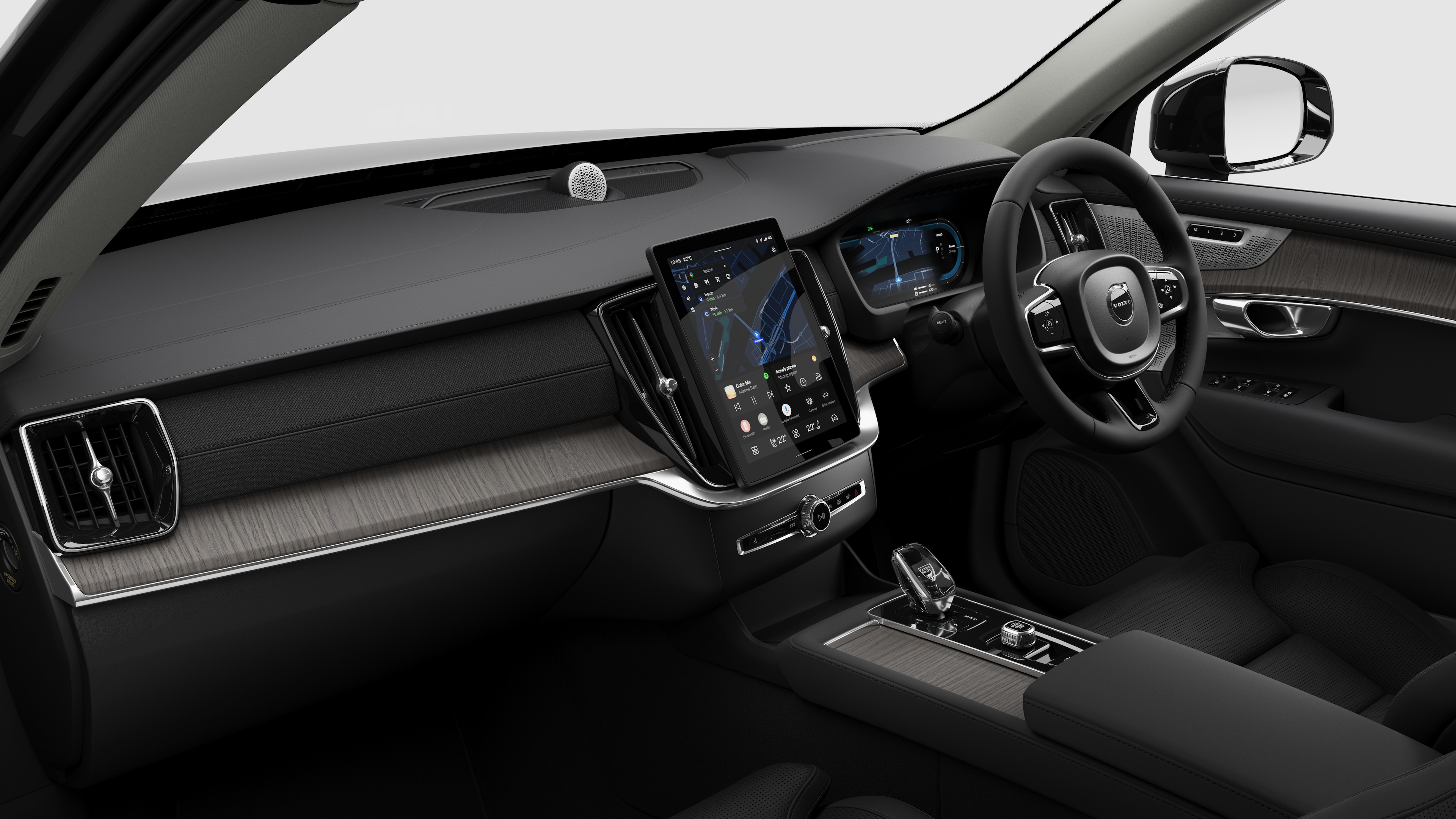 Interior view of a Volvo car showing the dashboard, steering wheel, center console, and digital display screen in a plain studio background.