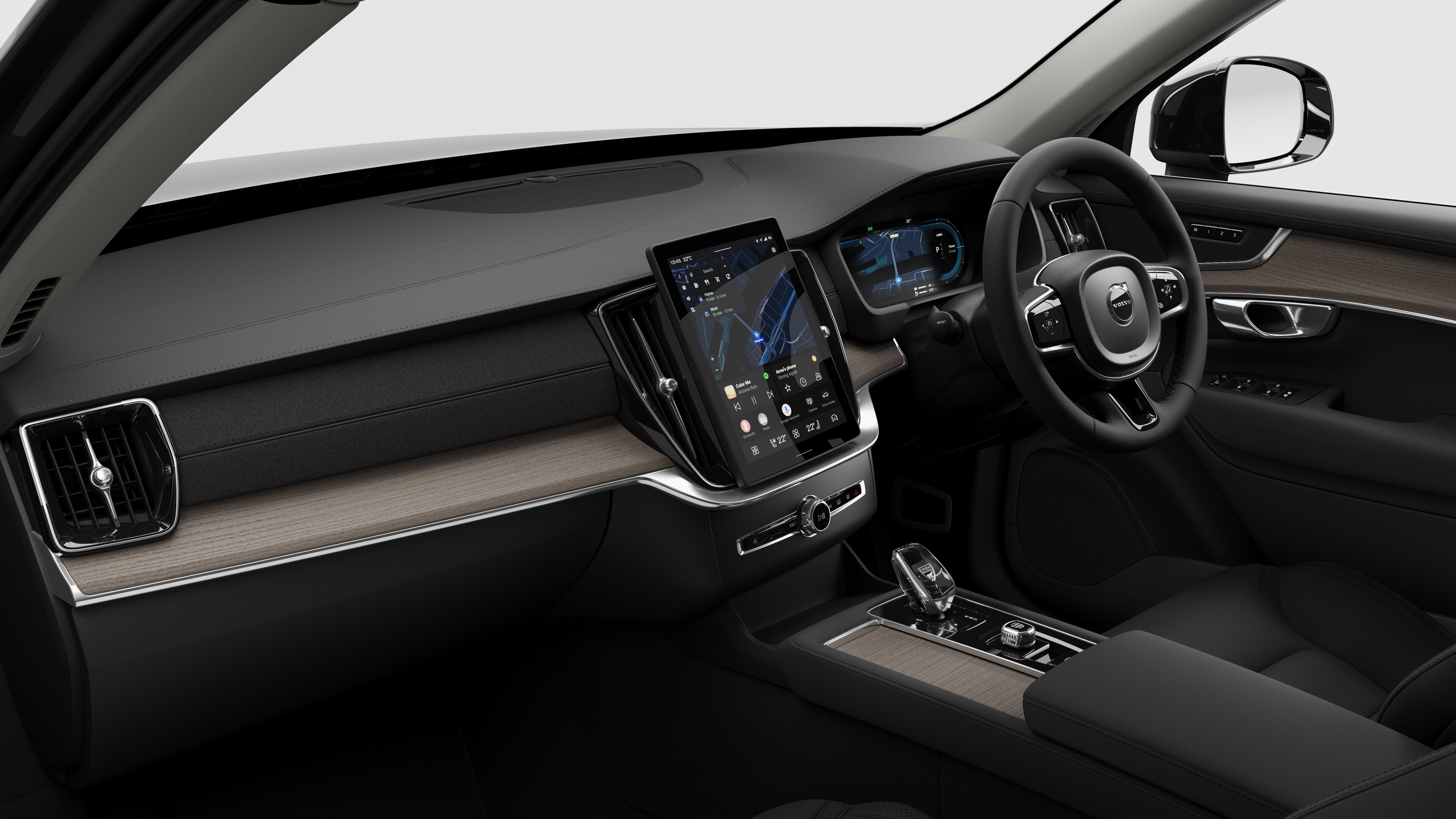 Interior view of a Volvo car showing the dashboard, steering wheel, center console, and digital display screen in a plain studio background.