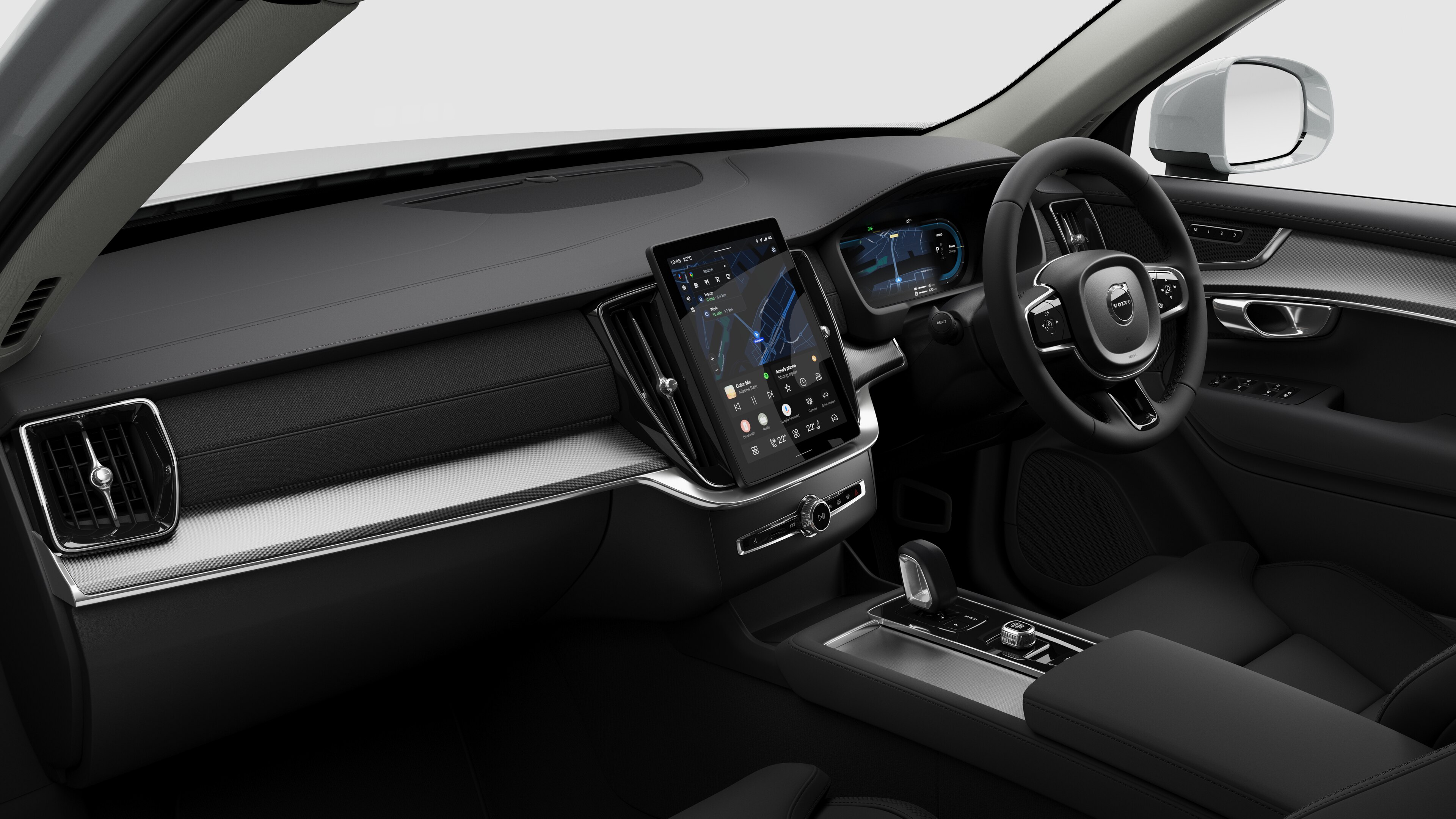 Interior view of a Volvo car showing the dashboard, steering wheel, center console, and digital display screen in a plain studio background.