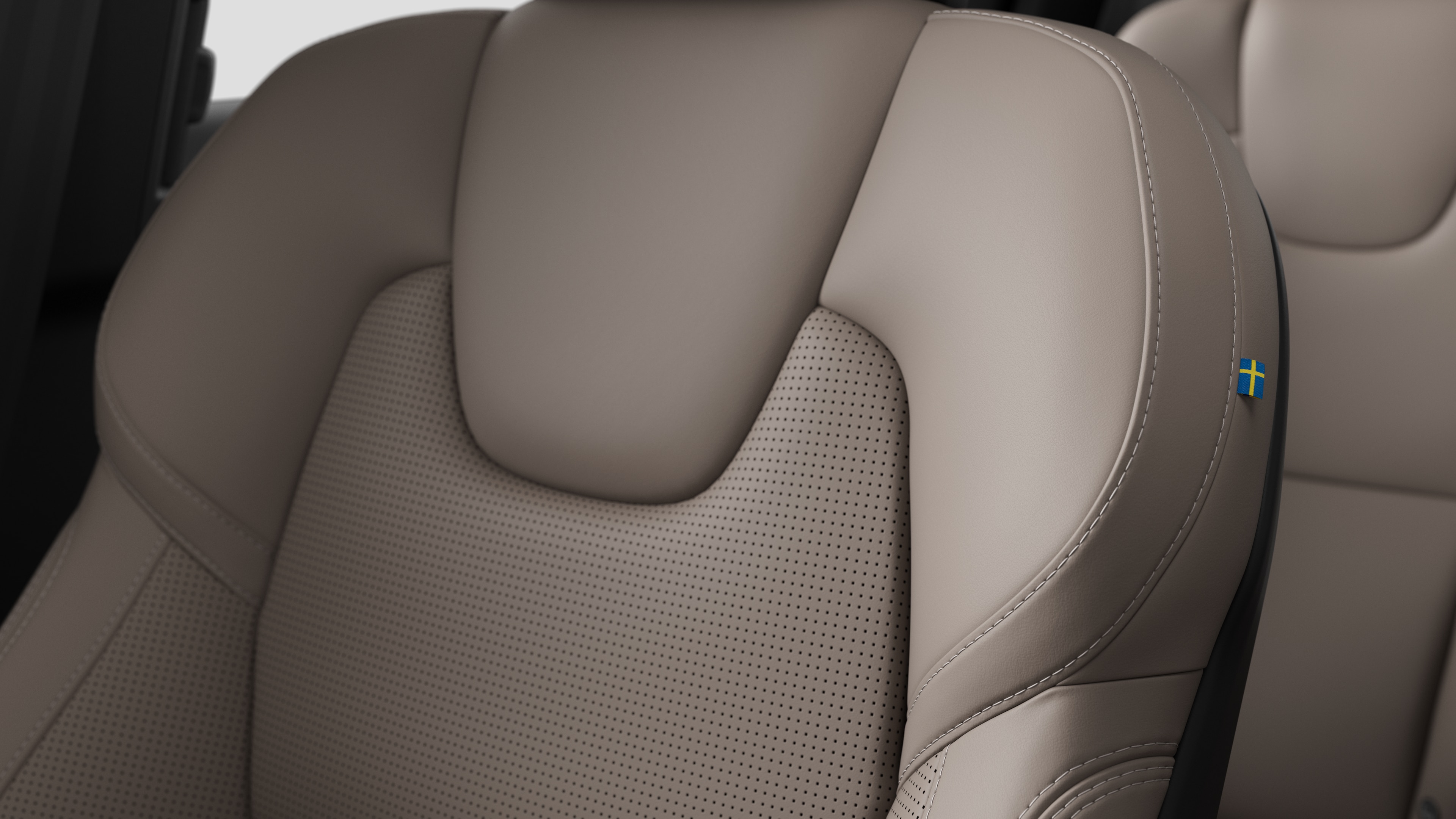 스티칭과 작은 스웨덴 국기 태그를 보여주는 볼보 자동차 내부 시트 디테일 클로즈업.