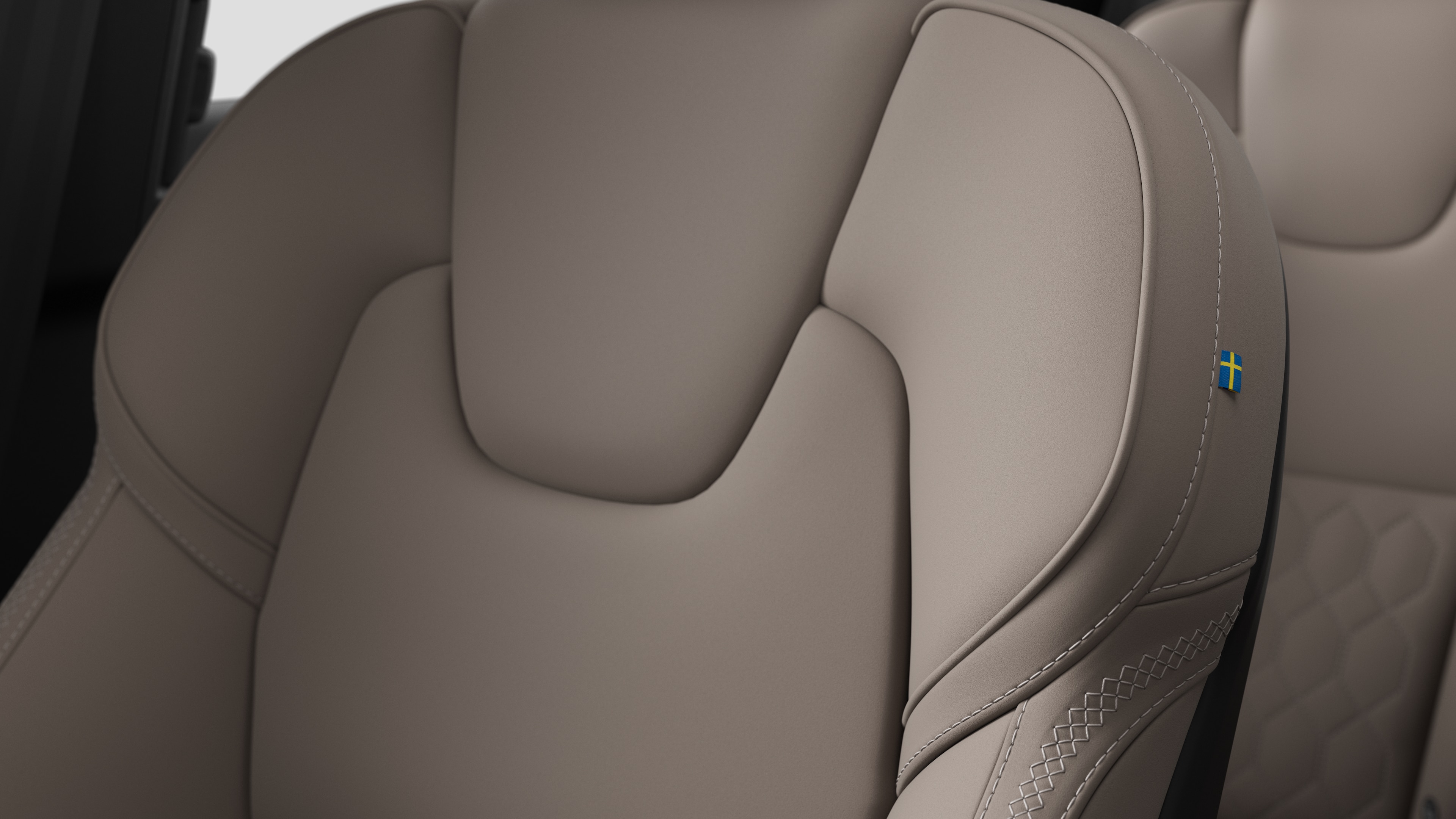 스티칭과 작은 스웨덴 국기 태그를 보여주는 볼보 자동차 내부 시트 디테일 클로즈업.