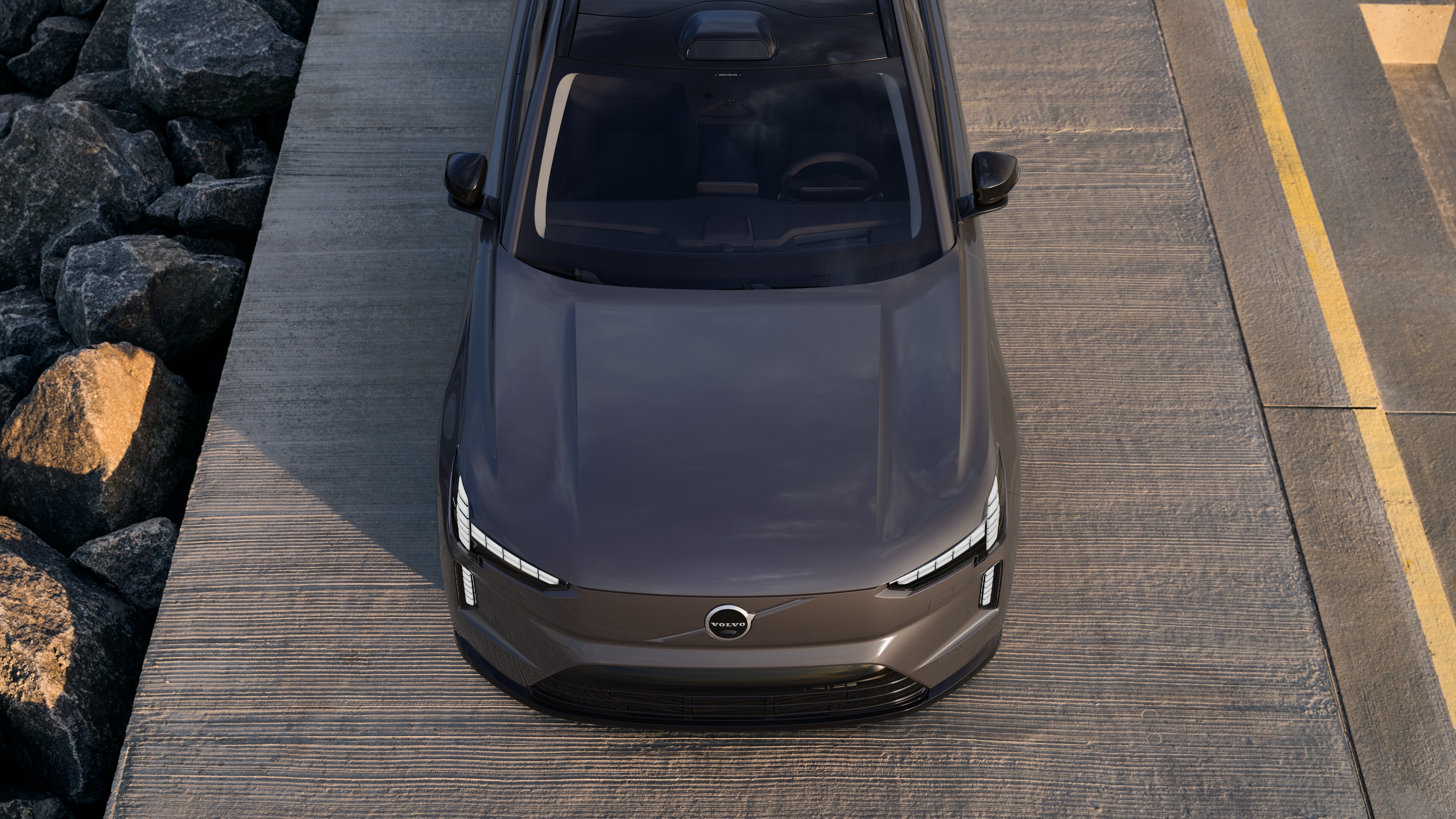 Volvo-auton ulkopuoli kolmen neljäsosan näkymässä kaupunkien katutaustalla, toinen puoli, katto ja osa edestä.