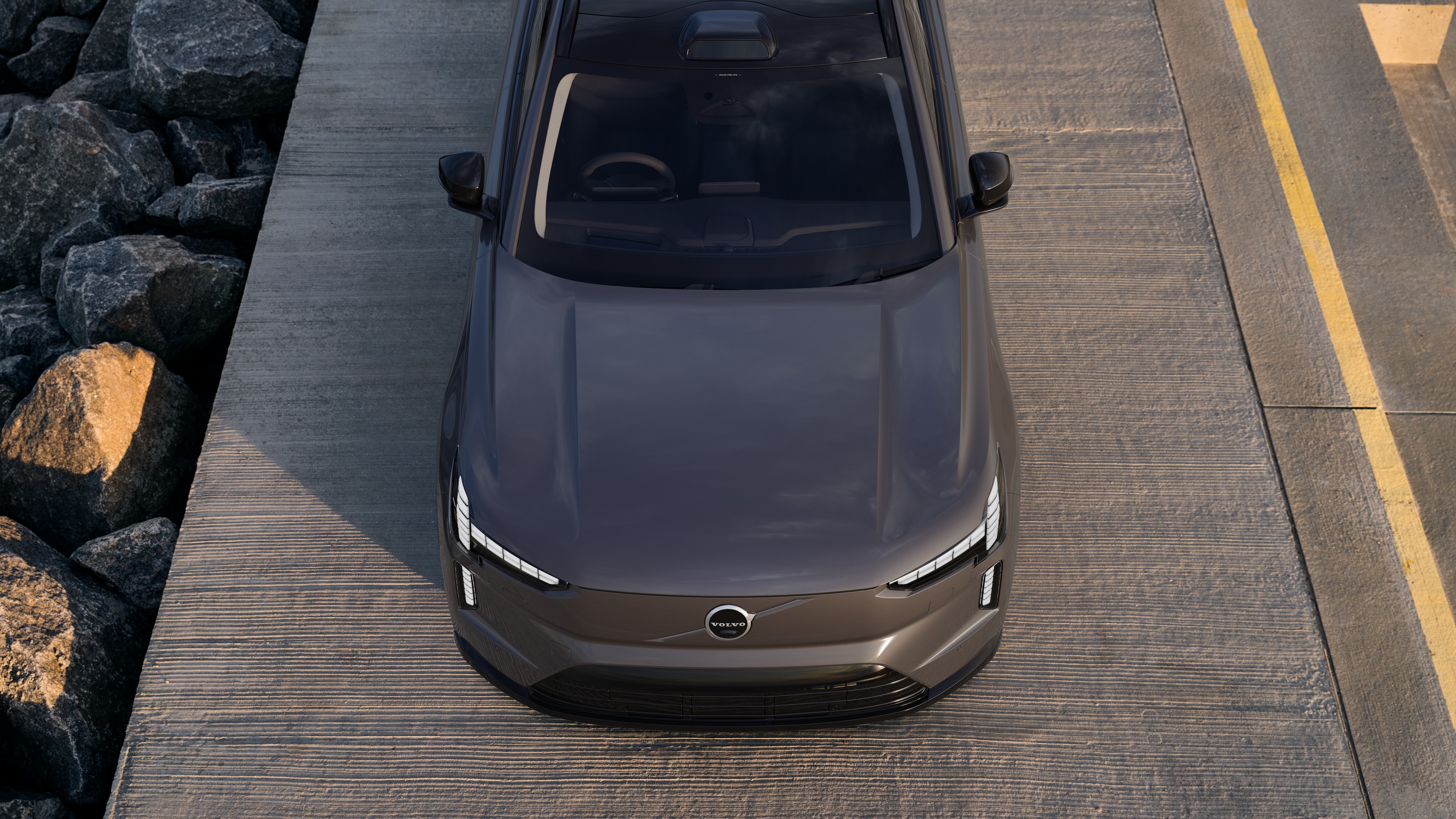 Volvo car exterior in three-quarter view on an urban street background, showing one side, roof, and part of the front.