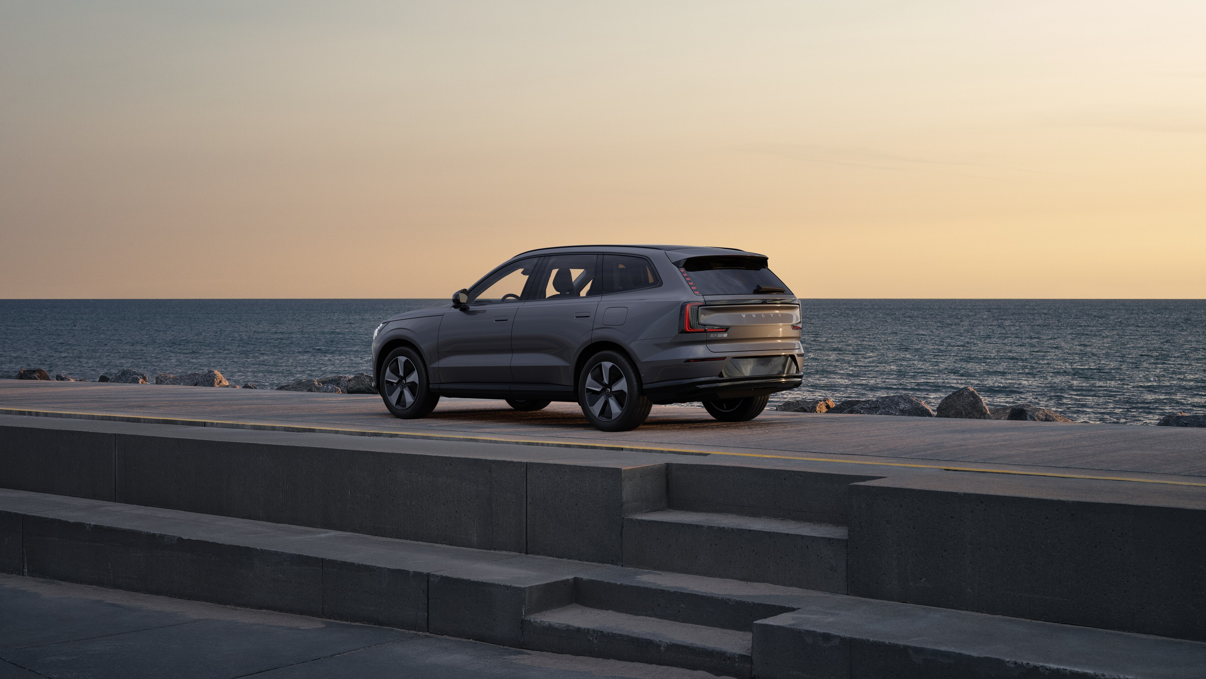 Dreiviertelansicht eines Volvo im Heck, der vor einer Betonwand auf einer städtischen Straße geparkt ist.
