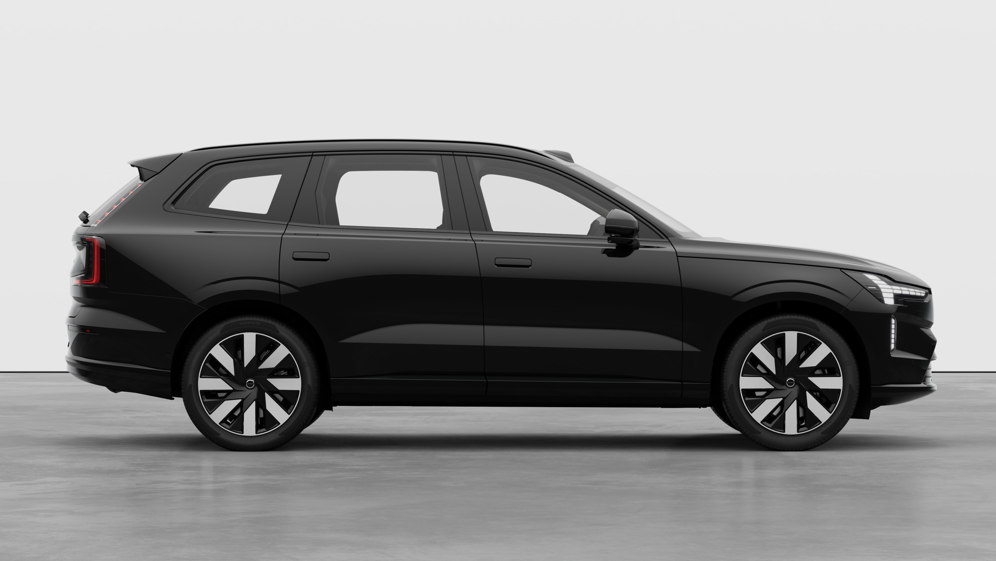 Volvo car side view on plain studio background displaying closed doors and visible wheel design.