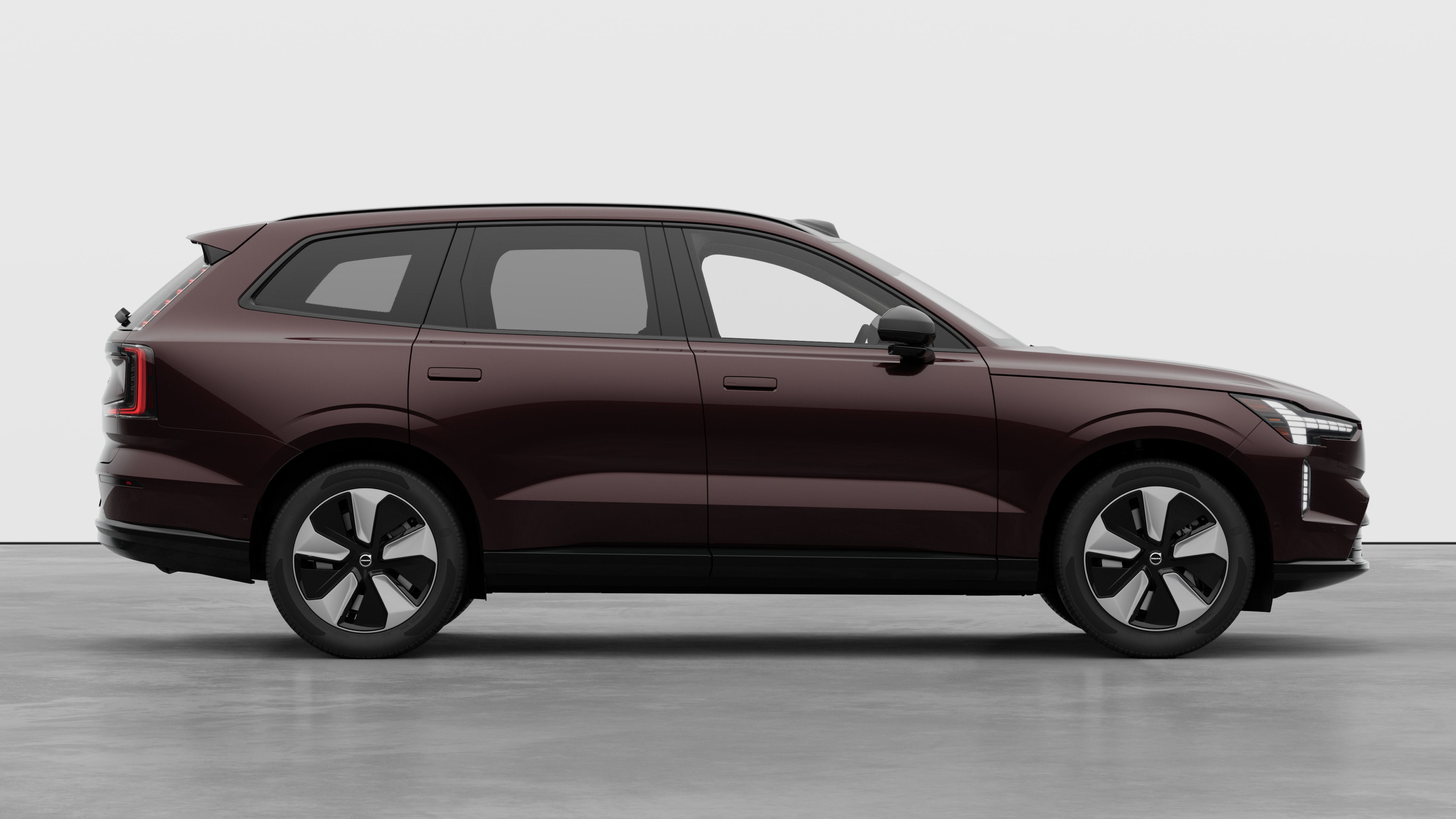 Volvo car side view on plain studio background displaying closed doors and visible wheel design.