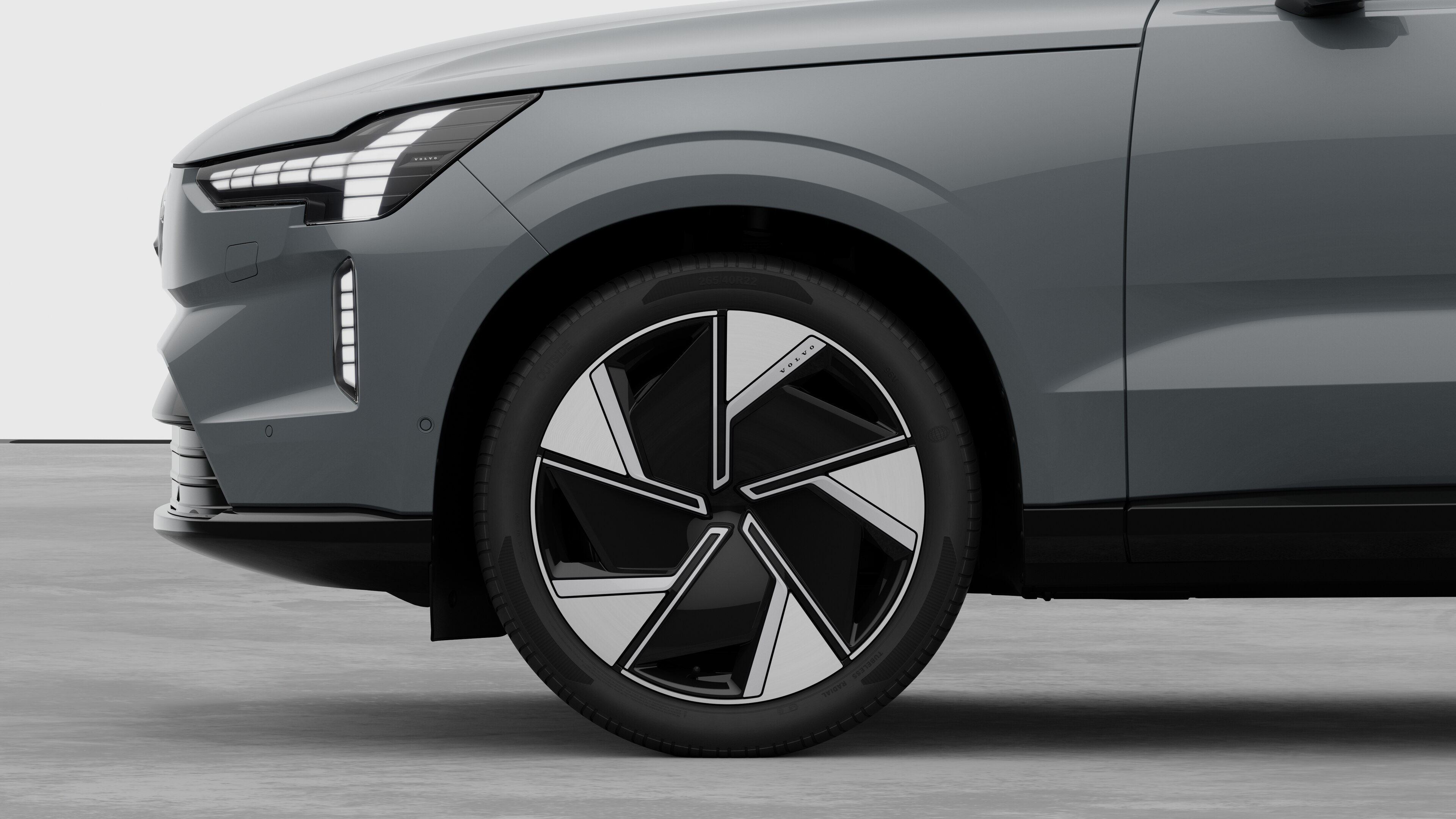 Volvo car exterior side view focusing on the front wheel and fender, set against a plain studio background.