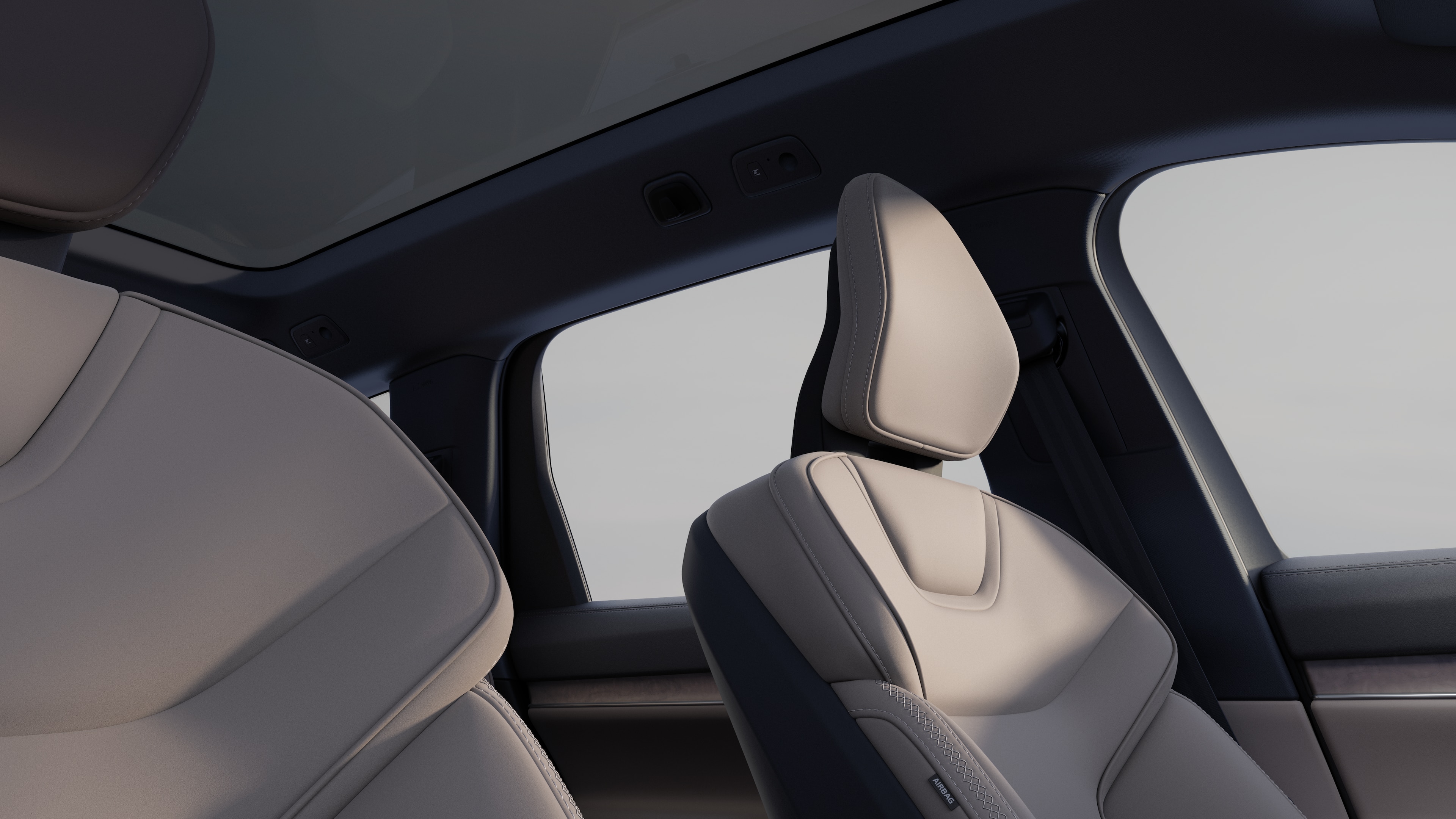 Volvo car interior showing front and rear passenger seats, steering wheel, dashboard, and center console against a plain studio background.
