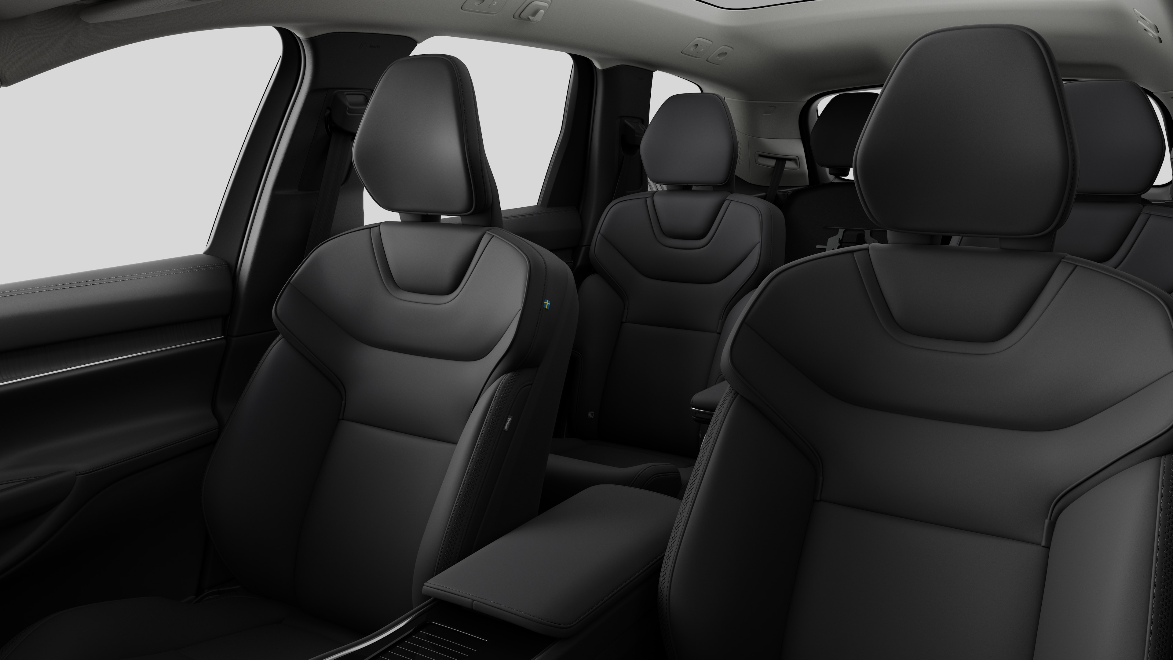 Interieur van de Volvo met de passagiersstoelen achteraan en de middenconsole op een effen studioachtergrond.