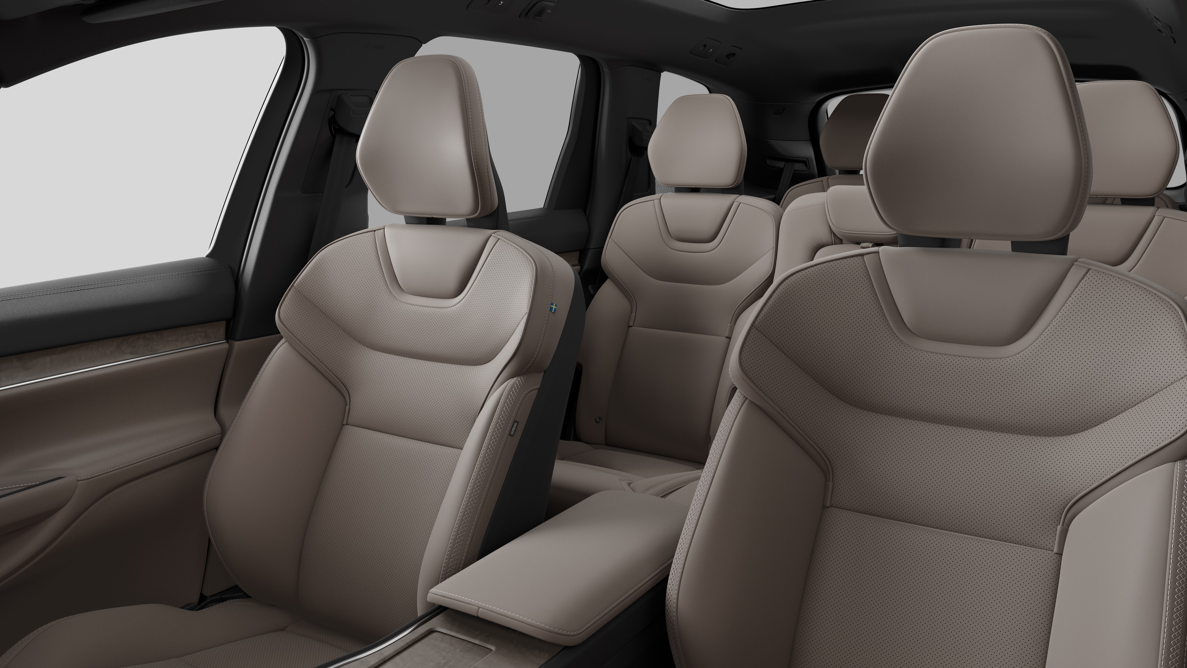 Interior del vehículo Volvo que muestra los asientos traseros del pasajero y la consola central en un fondo de estudio liso.