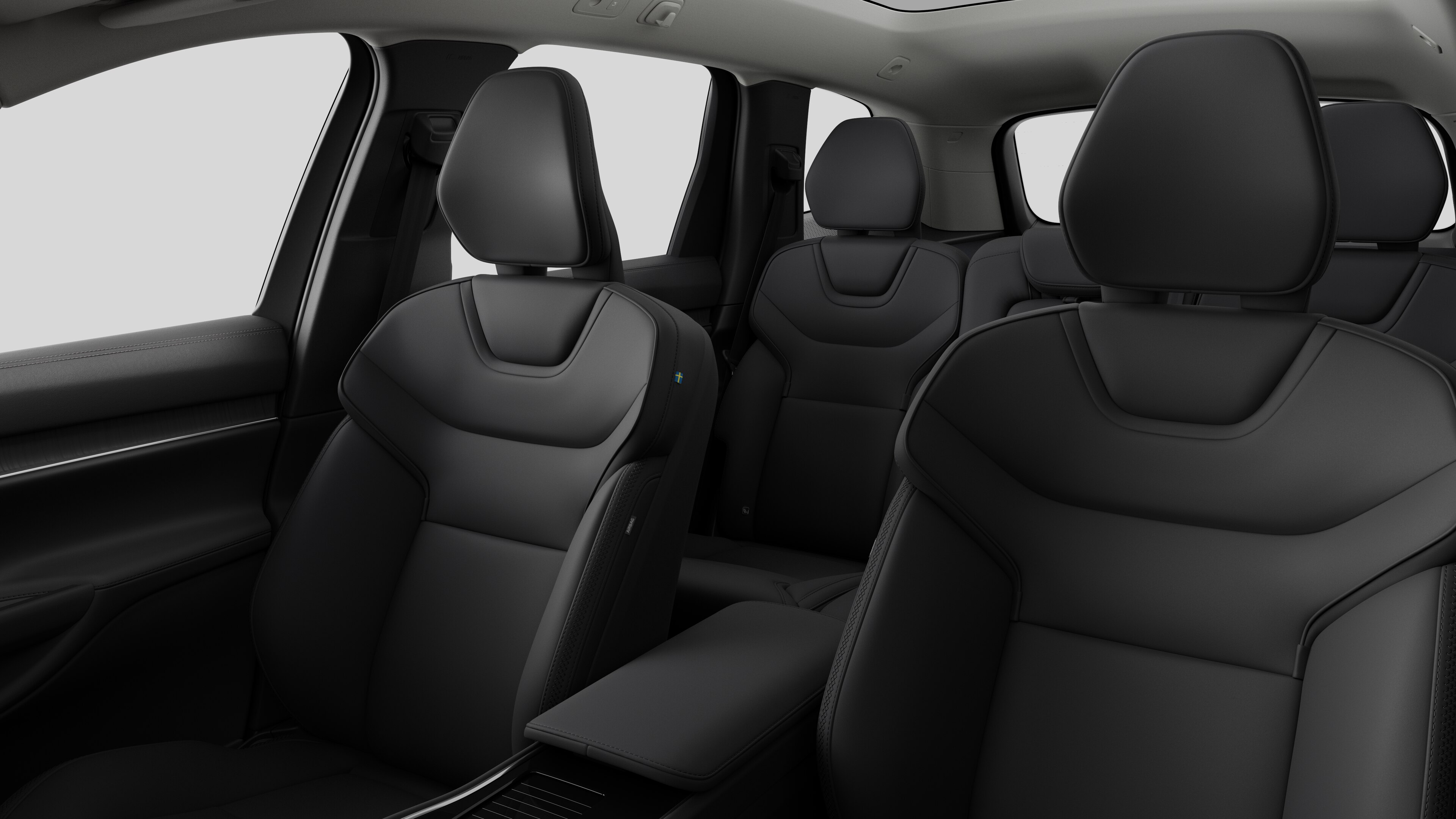 Interiér vozu Volvo se zadními sedadly spolujezdce a středovou konzolou v jednoduchém studiovém pozadí.