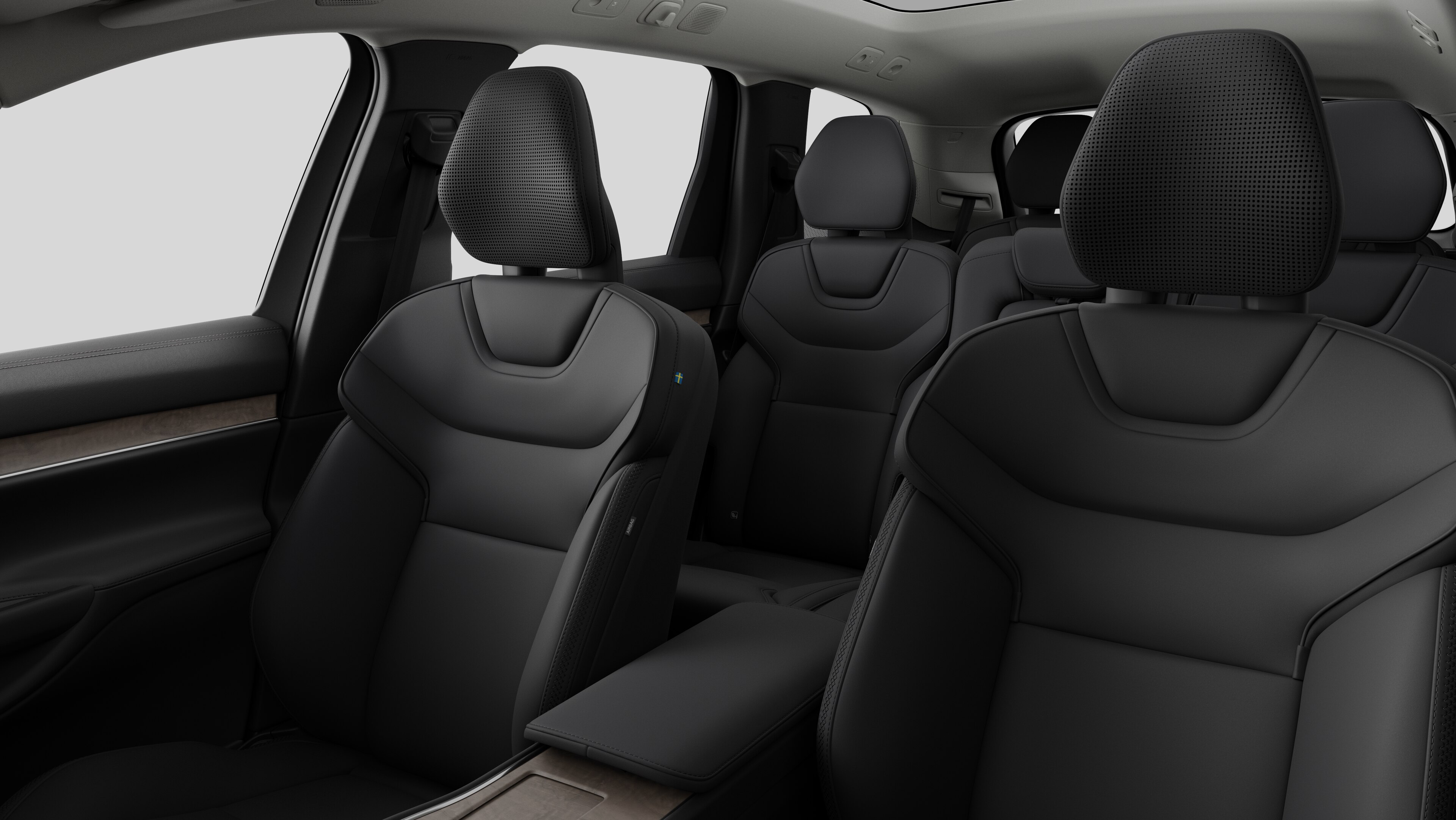 Interior del vehículo Volvo que muestra los asientos traseros del pasajero y la consola central en un fondo de estudio liso.
