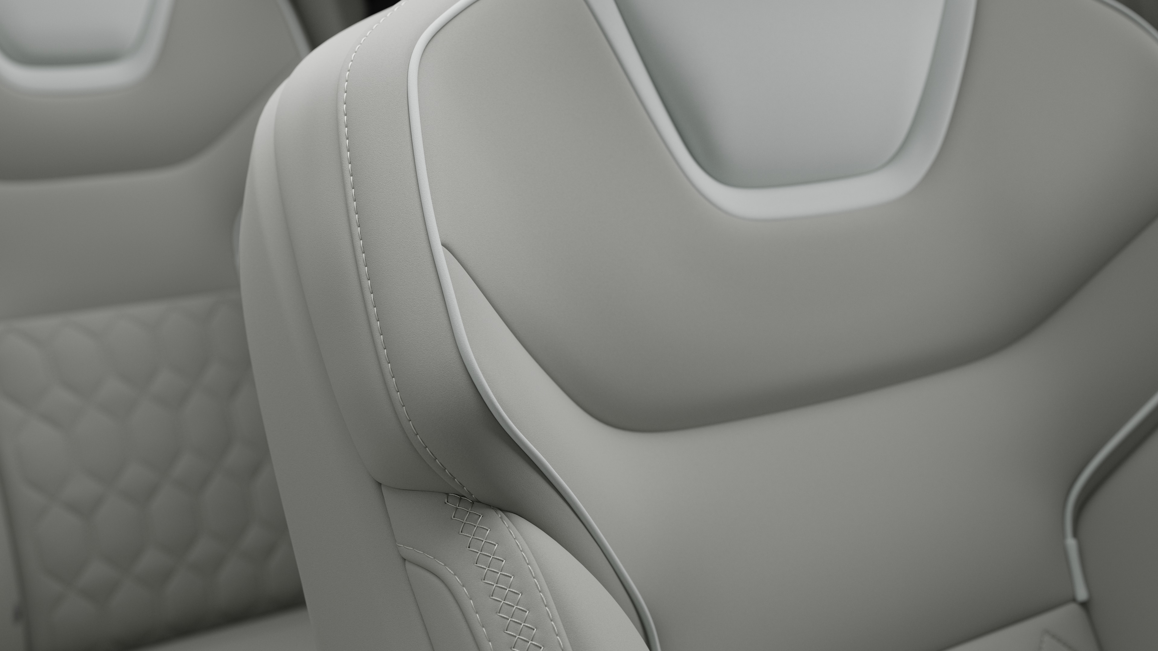 Close-up of Volvo car interior seat detail showing stitching and a small Swedish flag tag.