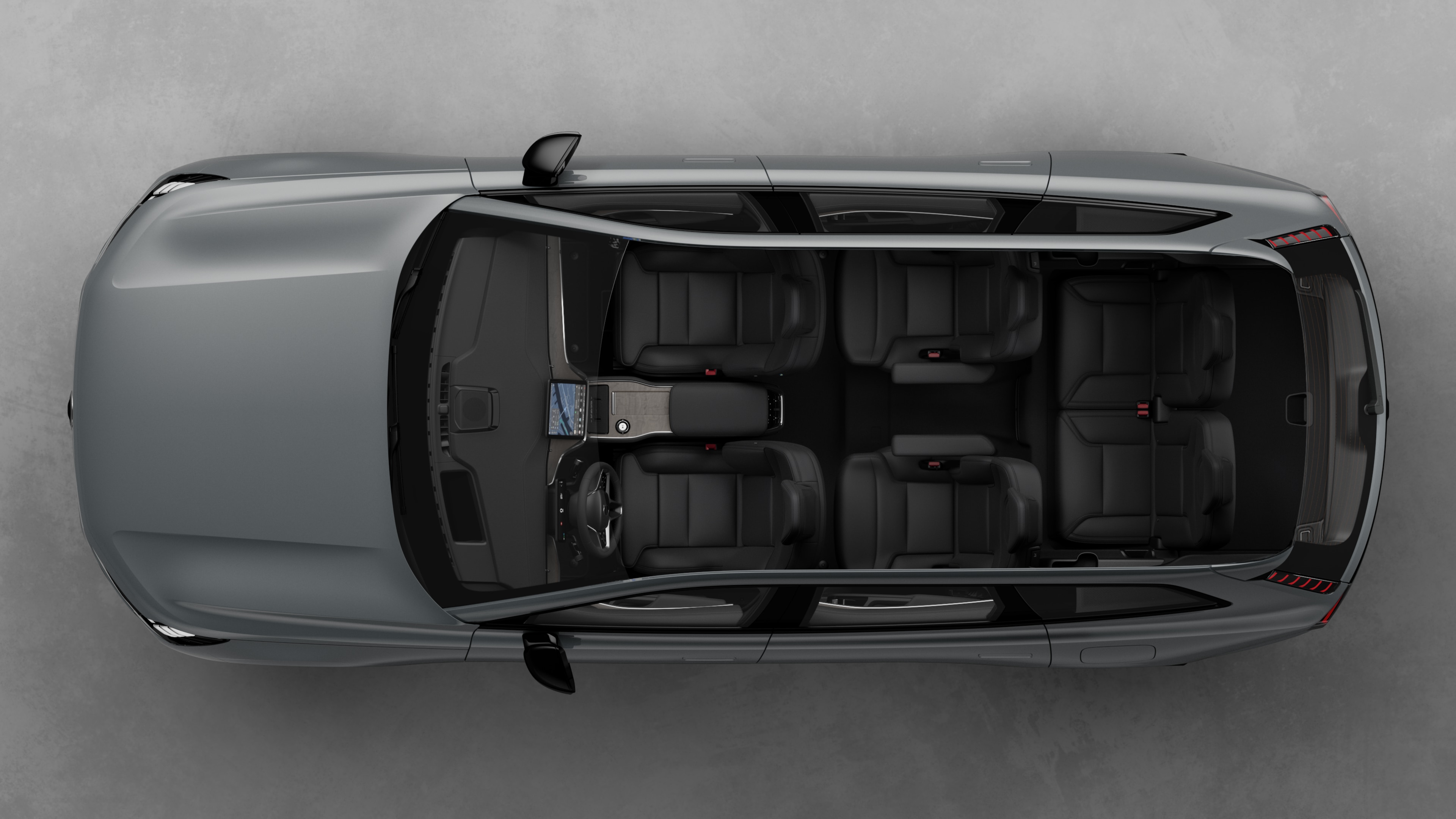 Toppvisning av Volvos interiør, som viser to seterader, dashbord og midtkonsoll, satt mot en vanlig studiobakgrunn.