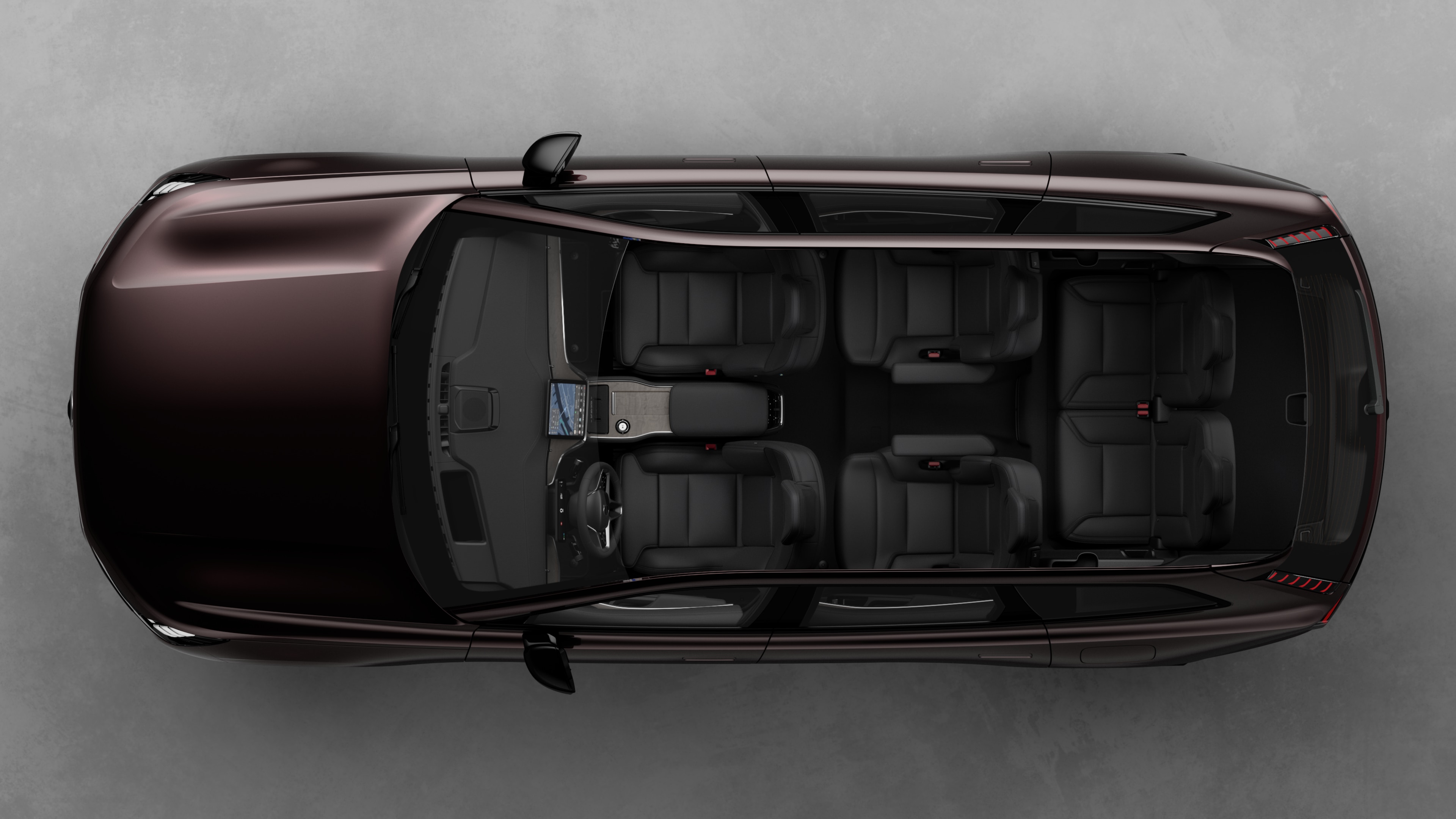 Top view of Volvo car interior, showing two rows of seats, dashboard, and center console, set against a plain studio background.