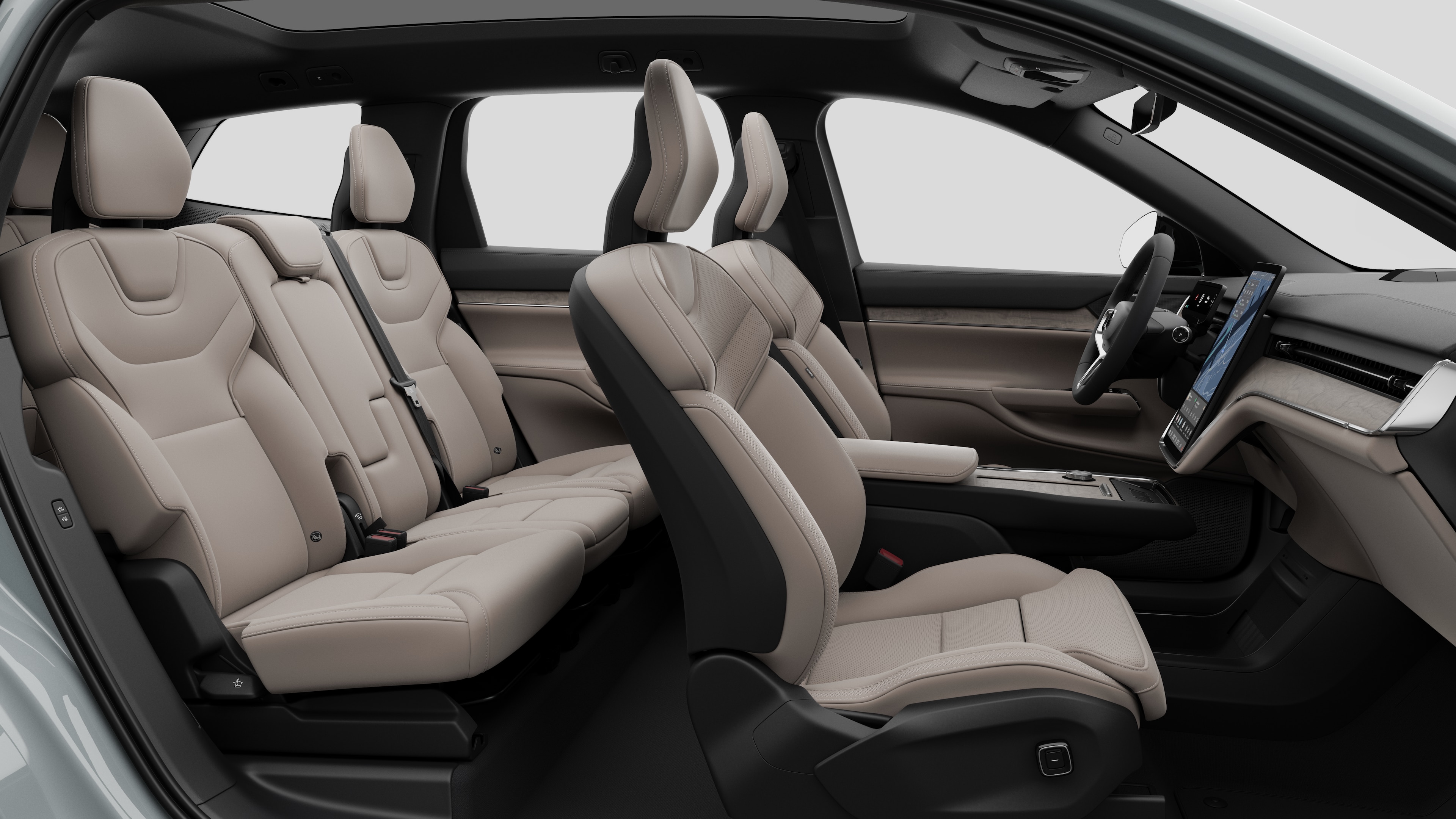 Zijaanzicht van het interieur van een Volvo met de voorstoelen, de passagiersstoelen achterin, het stuur, het dashboard en de middenconsole, tegen een effen studioachtergrond.