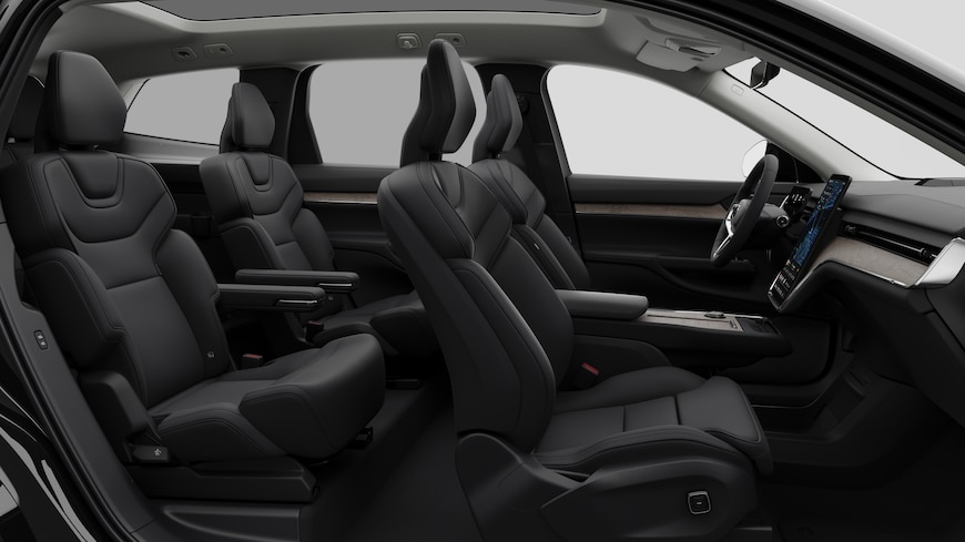 Volvo car interior side view showcasing front seats, rear passenger seats, steering wheel, dashboard, and center console, set against plain studio background.