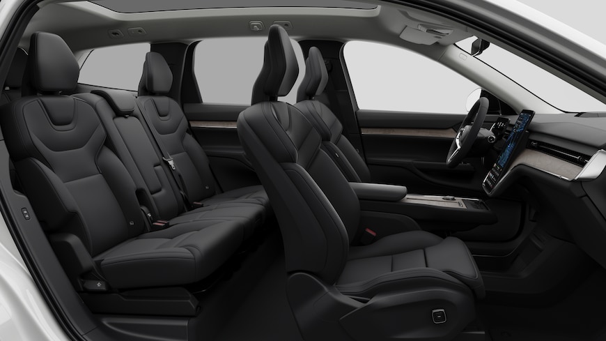 Volvo car interior side view showcasing front seats, rear passenger seats, steering wheel, dashboard, and center console, set against plain studio background.