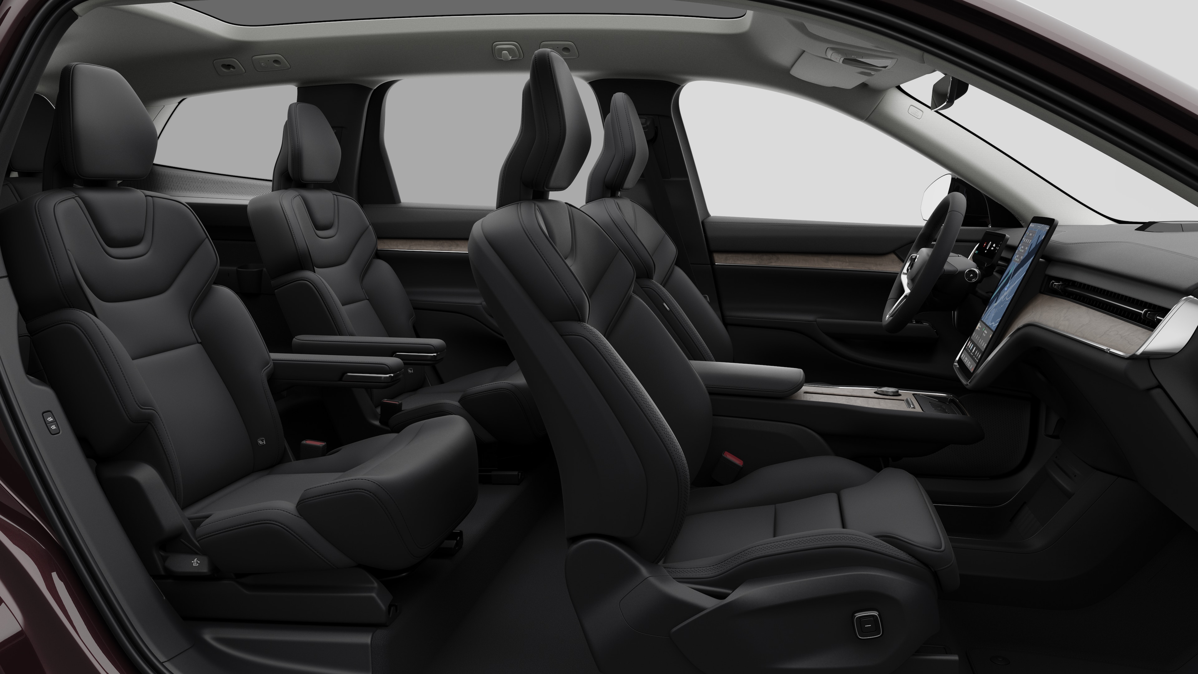 Volvo car interior side view showcasing front seats, rear passenger seats, steering wheel, dashboard, and center console, set against plain studio background.