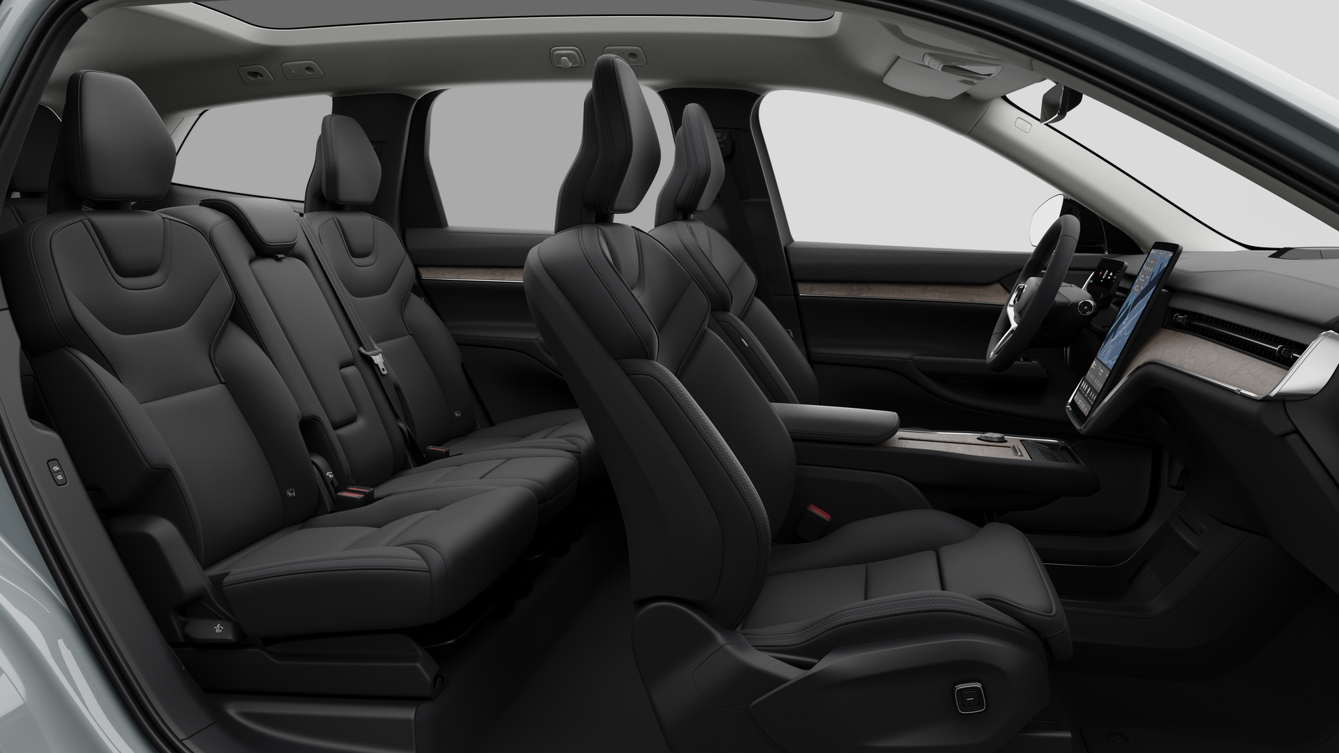 Vue latérale de l’intérieur d’une Volvo montrant les sièges avant, les sièges passager arrière, le volant, le tableau de bord et la console centrale, sur fond de studio.