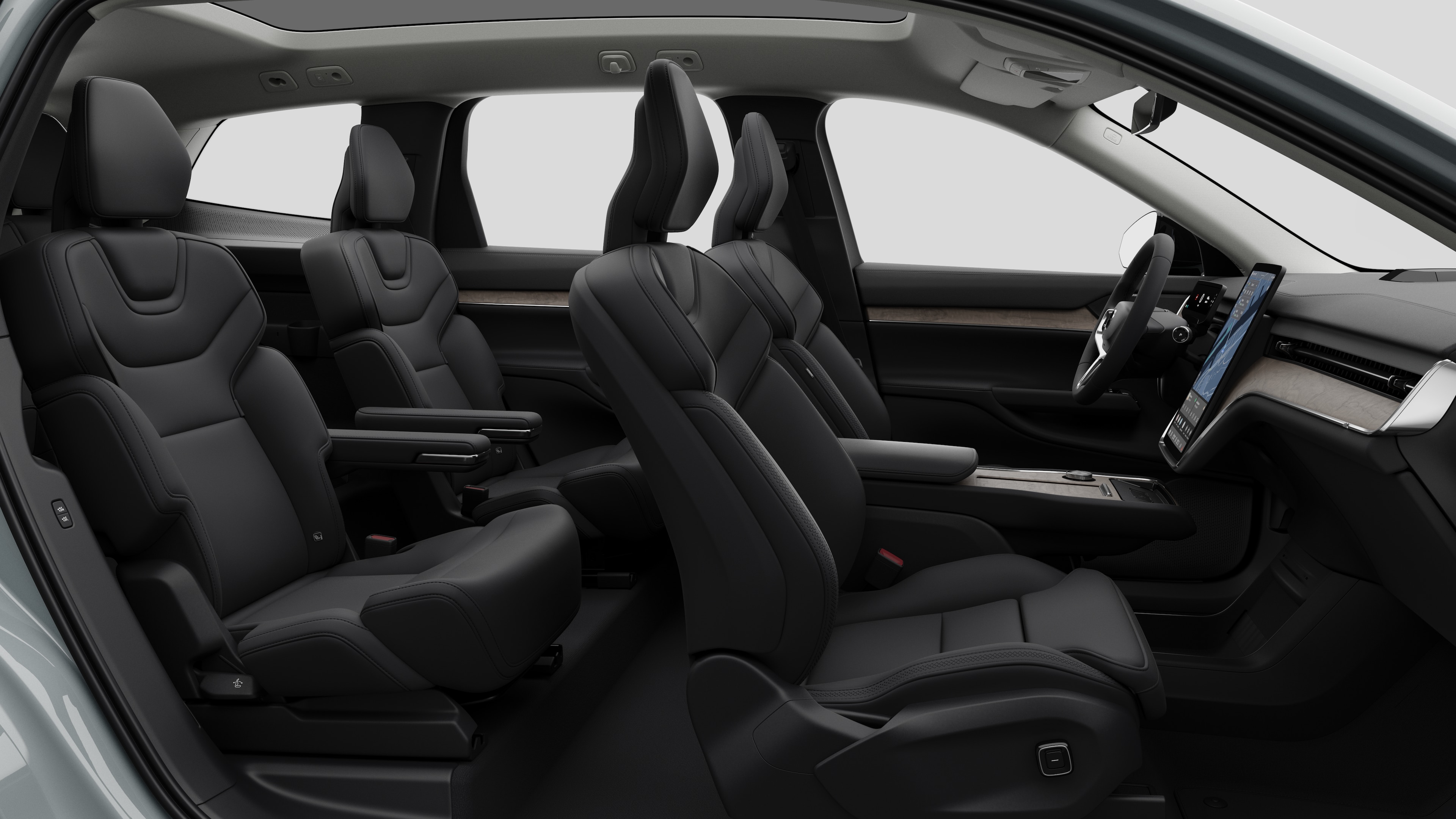 Volvos innvendige sidevisning med forseter, bakseter, ratt, dashbord og midtkonsoll, satt mot vanlig studiobakgrunn.