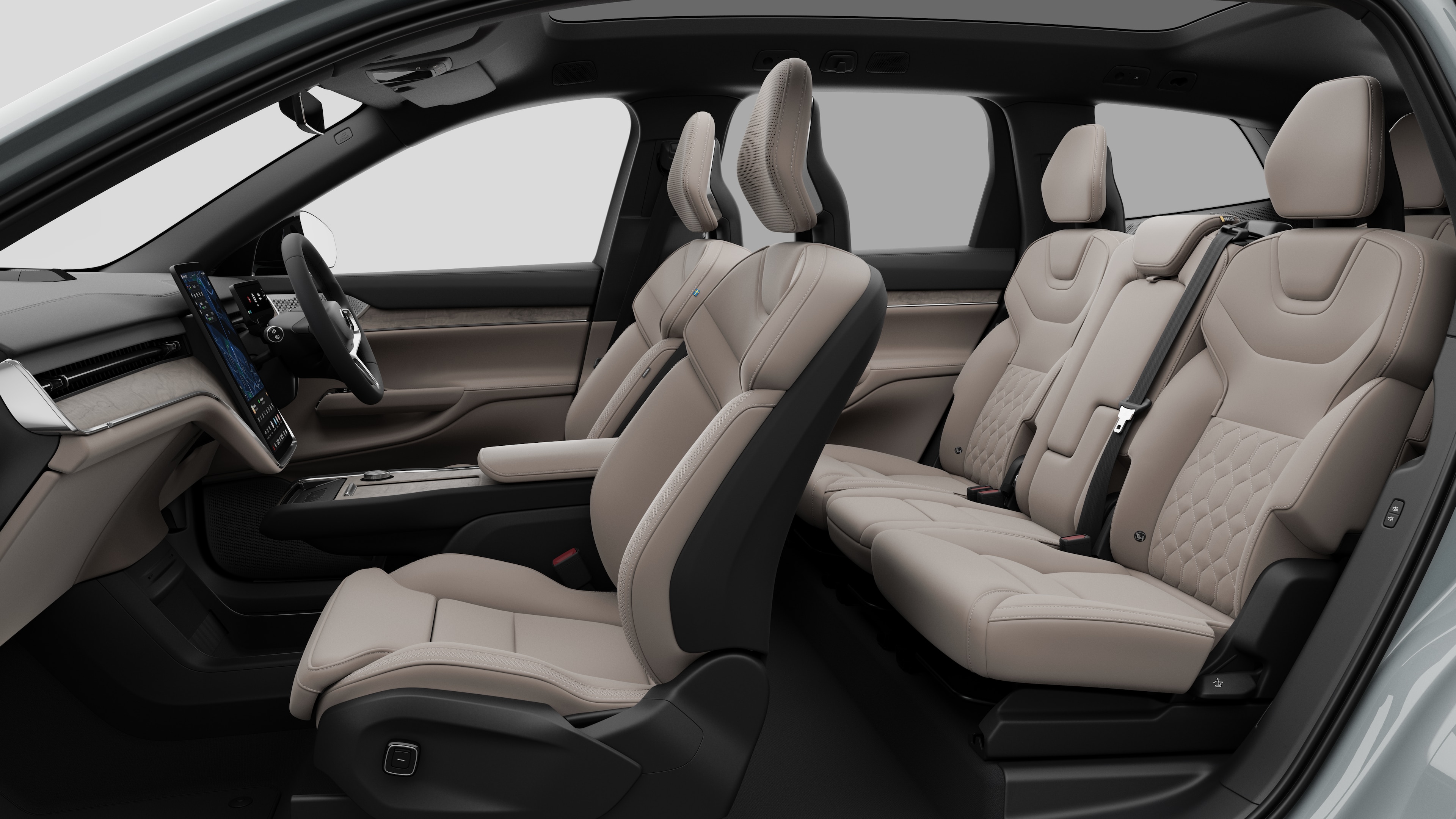 Volvo car interior side view showcasing front seats, rear passenger seats, steering wheel, dashboard, and centre console, set against plain studio background.