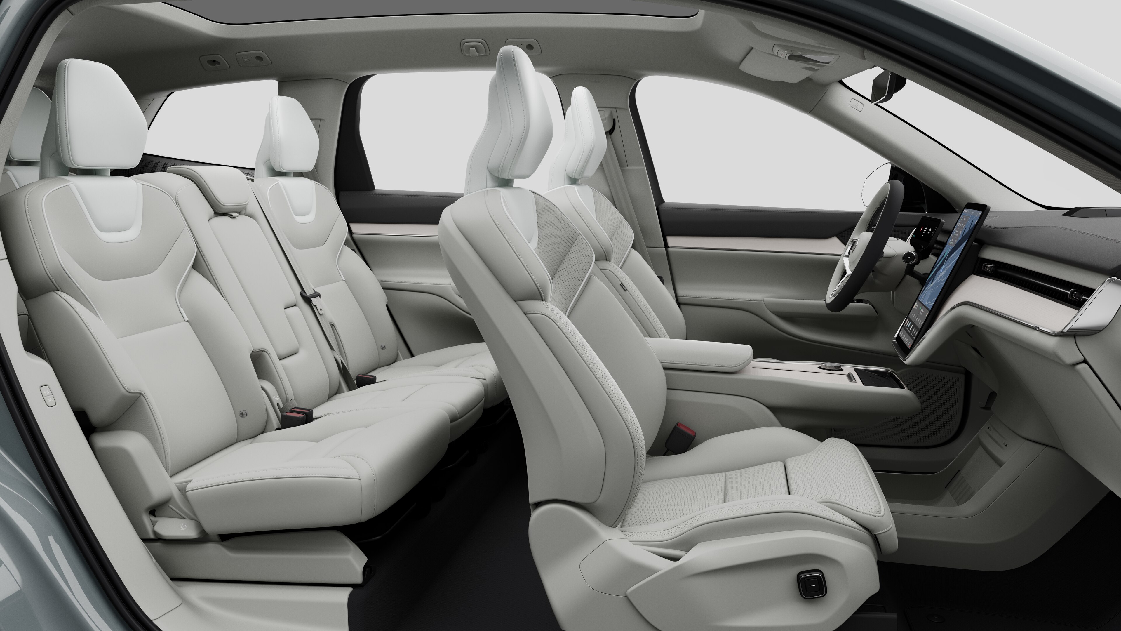 Zijaanzicht van het interieur van een Volvo met de voorstoelen, de passagiersstoelen achterin, het stuur, het dashboard en de middenconsole, tegen een effen studioachtergrond.