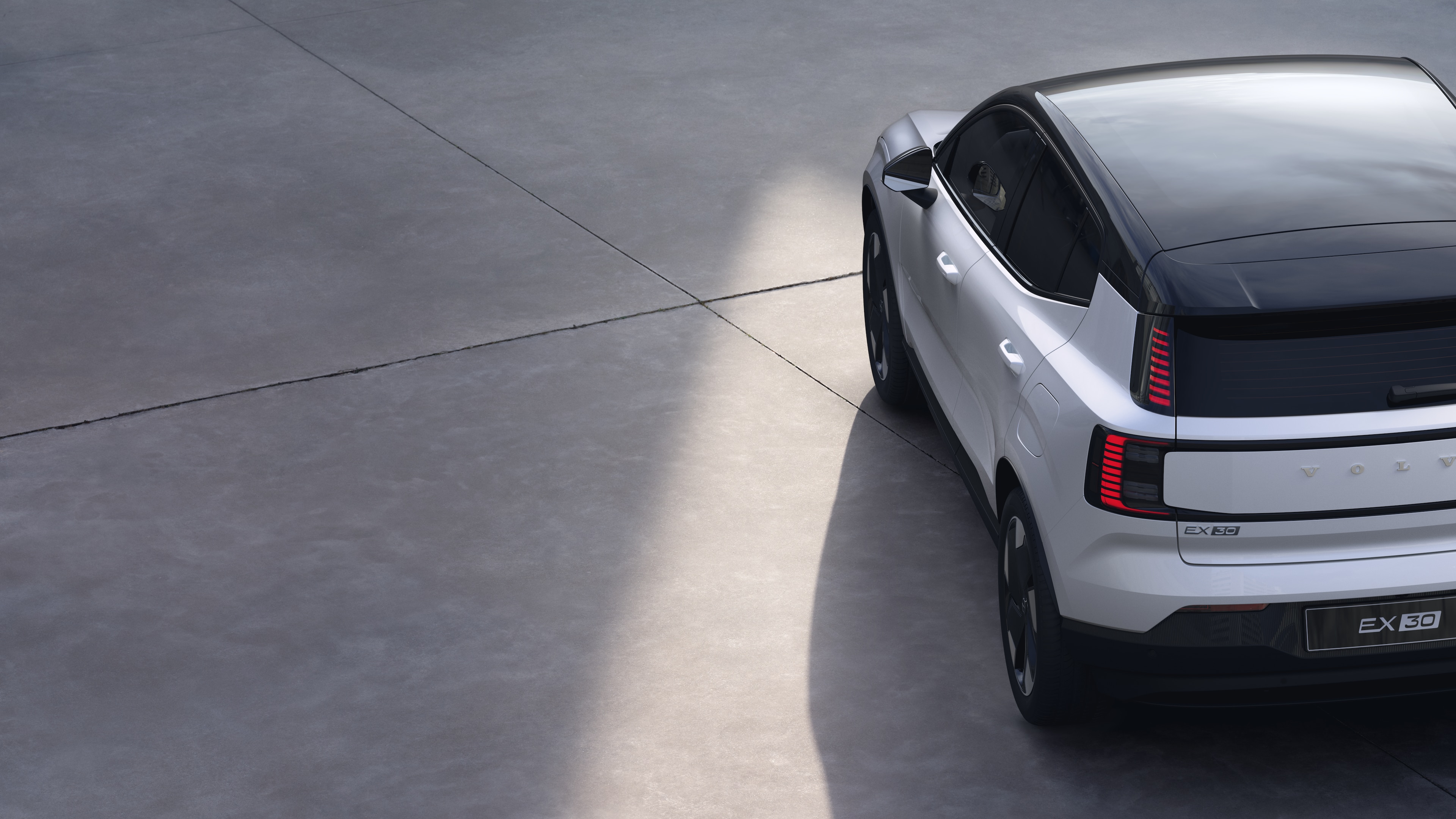 Vista trasera de tres cuartos del automóvil Volvo sobre fondo de estudio liso, que muestra el diseño de las luces traseras y la estructura de la ventana trasera para los detalles exteriores.