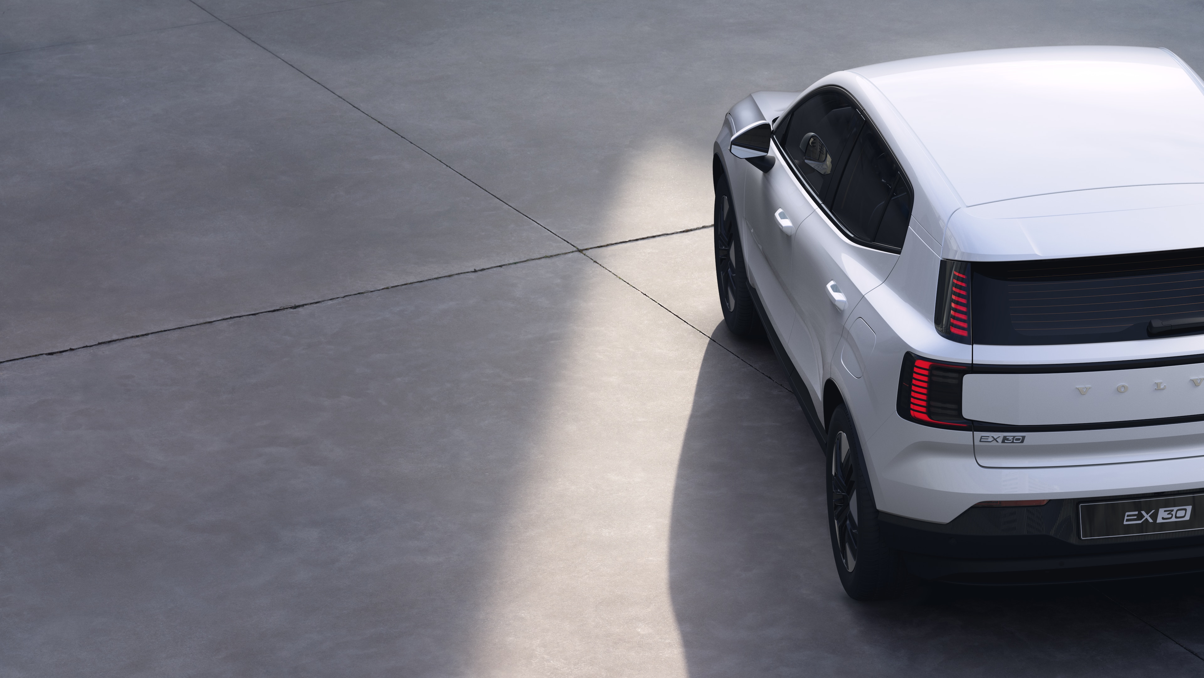 Vista trasera de tres cuartos del automóvil Volvo sobre fondo de estudio liso, que muestra el diseño de las luces traseras y la estructura de la ventana trasera para los detalles exteriores.
