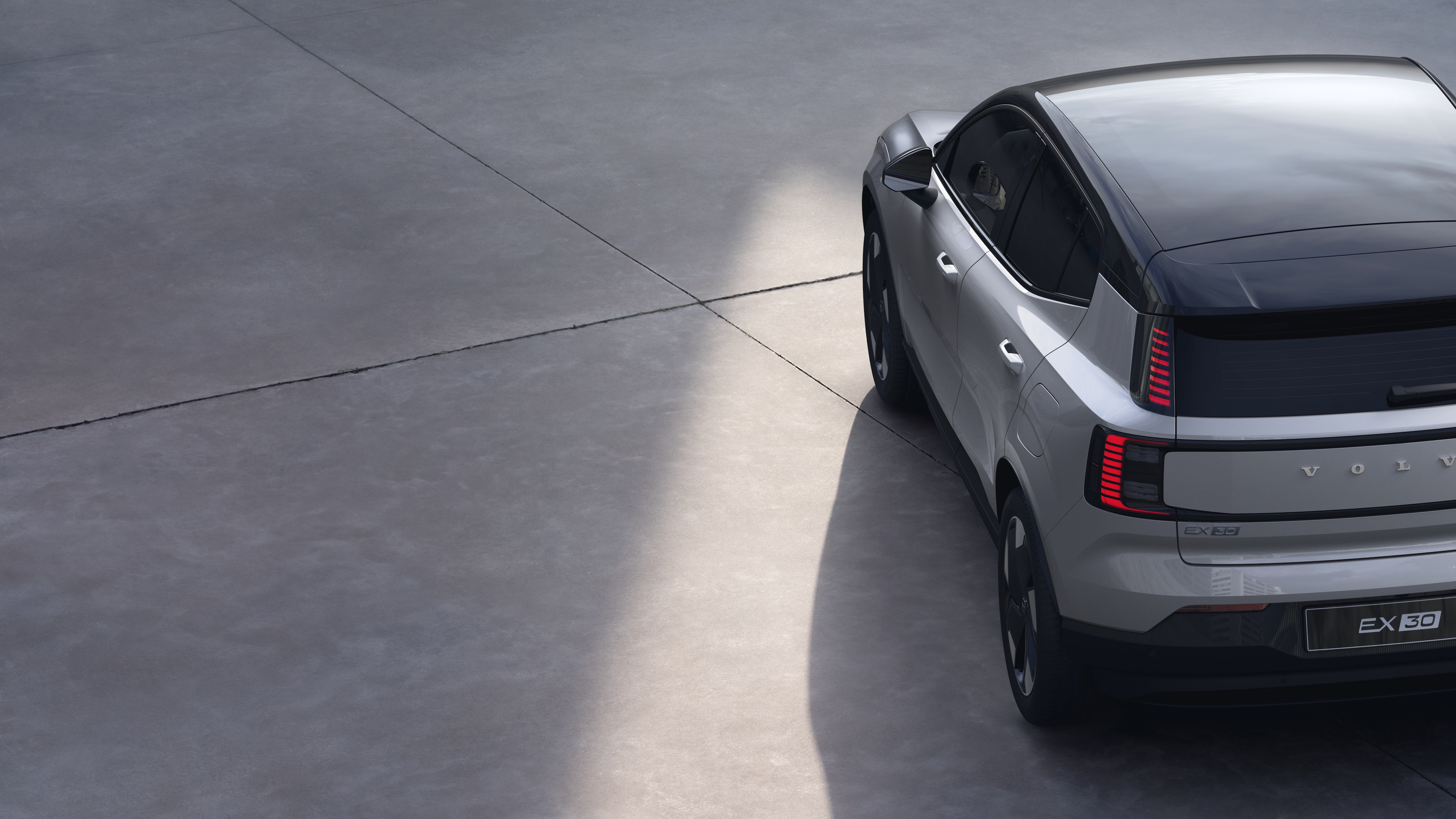 Vista trasera de tres cuartos del automóvil Volvo sobre fondo de estudio liso, que muestra el diseño de las luces traseras y la estructura de la ventana trasera para los detalles exteriores.